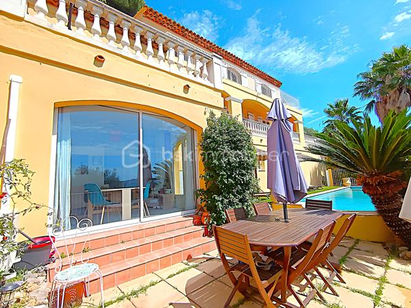 OLLIOULES – LA COURTINE

Villa avec vue panoramique, piscine à débordement et appartement indépendant

Une vue panoramique dont on ne se lasse jamais, une piscine à débordement semblant se fondre dans le paysage et un environnement préservé à quelques minutes seulement du centre d'Ollioules.

Dans l'un des secteurs résidentiels les plus recherchés de la commune, cette propriété offre un cadre de vie privilégié où intimité, lumière et panorama exceptionnel se conjuguent au quotidien.

Nichée au bout d'une impasse, à l'abri des regards, cette élégante villa construite en 2003 développe environ 225 m² habitables sur un terrain paysager de 1 662 m².

Dès les premiers instants, le charme opère.

Les volumes généreux, la luminosité omniprésente et l'ouverture permanente sur l'extérieur créent une atmosphère à la fois chaleureuse et apaisante.

Le niveau principal accueille plus de 100 m² de plain-pied baignés de lumière grâce à son exposition Sud-Sud-Ouest.

Il comprend :

• Une entrée avec dressing
• Un vaste espace de vie de près de 64 m² avec cheminée
• Une cuisine familiale entièrement équipée
• Une suite parentale avec salle d'eau privative et accès direct à la terrasse

Chaque espace profite pleinement de la vue spectaculaire qui accompagne le quotidien et prolonge naturellement les pièces de vie vers l'extérieur.

À l'étage, l'espace nuit accueille trois chambres bénéficiant chacune d'un accès direct au balcon panoramique ainsi qu'un bureau pouvant faire office de chambre supplémentaire, d'espace télétravail ou de salle de loisirs. Les autres espaces nuit se répartissent entre le niveau principal et l'appartement indépendant.

Pensée pour accueillir famille et amis dans les meilleures conditions, la propriété dispose également d'un appartement indépendant d'environ 54 m² avec terrasse privative.

Véritable atout de la propriété, cet espace complémentaire permet de recevoir en toute intimité, d'exercer une activité professionnelle indépendante ou d'envisager un revenu locatif.

À l'extérieur, le spectacle continue.

La piscine à débordement de 9 x 4 mètres semble se fondre dans le paysage et offre un point de vue privilégié sur les collines du littoral varois.

Les terrasses, espaces détente et coins repas invitent à profiter pleinement du climat méditerranéen et des couchers de soleil qui rythment les saisons.

Deux vastes restanques supplémentaires offrent encore de nombreuses possibilités d'aménagement selon vos envies : jardin méditerranéen, terrain de pétanque, espace de loisirs ou projet paysager personnalisé.

Les prestations :

• Environ 225 m² habitables
• Terrain de 1 662 m²
• Construction de 2003
• 5 chambres + 1 bureau
• 3 salles d'eau dont une à personnaliser
• Appartement indépendant de 54 m²
• Piscine à débordement 9 x 4 m
• Pompe à chaleur récente (2024)
• Climatisation réversible
• Double vitrage
• Garage de 20 m²
• Nombreuses places de stationnement
• Portail automatique

À seulement quelques minutes du centre historique d'Ollioules, des commerces, des écoles et des principaux axes de communication, cette propriété conjugue parfaitement tranquillité, confort et proximité.

Les propriétés offrant une telle combinaison de vue panoramique, d'intimité, d'espaces extérieurs, de potentiel d'accueil et de proximité avec le centre d'Ollioules sont particulièrement rares sur le secteur.

Ici, les saisons défilent, la lumière évolue au fil des heures et le panorama reste toujours aussi spectaculaire.

Visite exclusivement sur rendez-vous.

Kévin LEXA
BSK Immobilier
Disponible 7J/7