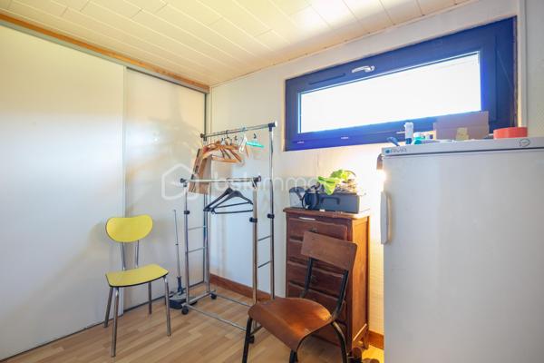Bâtie en 1963, cette maison familiale offre de beaux volumes et un fort potentiel d’aménagement.

Au rez-de-chaussée, vous découvrirez une vaste entrée pouvant faire office de salon ou de pièce de vie supplémentaire, une buanderie, une chaufferie, une cave en terre battue ainsi qu’un grand garage permettant de stationner un véhicule et plusieurs motos.

À l’étage, l'habitation se compose d’un salon-salle à manger lumineux, d’une cuisine aménagée donnant accès à un balcon périphérique. Un couloir dessert également une salle d’eau, une toilette indépendante et deux belles chambres avec placards.

Les combles, déjà isolés, offrent un beau potentiel d’aménagement supplémentaire selon vos besoins.

Implantée sur un joli terrain plat, entièrement clôturé et piscinable de 829 m², la propriété bénéficie d’une belle luminosité grâce à ses larges ouvertures et son exposition plein sud.

Des travaux de rénovation énergétique ont déjà été réalisés, notamment les menuiseries et porte d’entrée en PVC, les volets roulants électriques et solaires, la VMC, la pompe à chaleur air/air...

La demeure est également raccordée au tout-à-l’égout.

Un léger rafraîchissement intérieur permettra de la remettre au goût du jour et de révéler tout son potentiel.