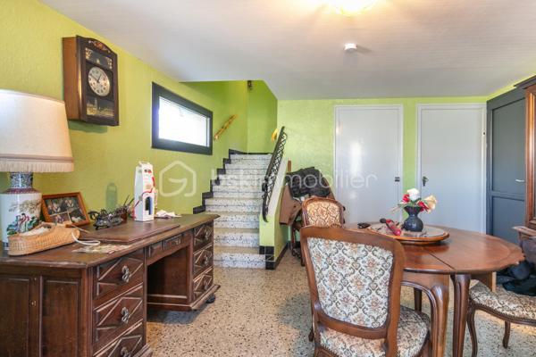 Bâtie en 1963, cette maison familiale offre de beaux volumes et un fort potentiel d’aménagement.

Au rez-de-chaussée, vous découvrirez une vaste entrée pouvant faire office de salon ou de pièce de vie supplémentaire, une buanderie, une chaufferie, une cave en terre battue ainsi qu’un grand garage permettant de stationner un véhicule et plusieurs motos.

À l’étage, l'habitation se compose d’un salon-salle à manger lumineux, d’une cuisine aménagée donnant accès à un balcon périphérique. Un couloir dessert également une salle d’eau, une toilette indépendante et deux belles chambres avec placards.

Les combles, déjà isolés, offrent un beau potentiel d’aménagement supplémentaire selon vos besoins.

Implantée sur un joli terrain plat, entièrement clôturé et piscinable de 829 m², la propriété bénéficie d’une belle luminosité grâce à ses larges ouvertures et son exposition plein sud.

Des travaux de rénovation énergétique ont déjà été réalisés, notamment les menuiseries et porte d’entrée en PVC, les volets roulants électriques et solaires, la VMC, la pompe à chaleur air/air...

La demeure est également raccordée au tout-à-l’égout.

Un léger rafraîchissement intérieur permettra de la remettre au goût du jour et de révéler tout son potentiel.