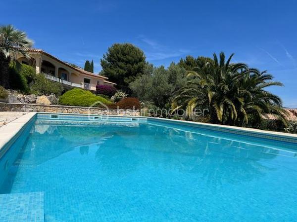 Découvrez cette propriété d’exception où élégance, volumes et douceur de vivre se rencontrent dans un cadre privilégié.

Édifiée sur un magnifique terrain de 3 939 m², cette villa de prestige développe près de 240 m² habitables, répartis entre une villa principale de plain-pied de 160 m² et une dépendance indépendante de 80 m². Un lieu pensé pour ceux qui recherchent espace, confort et sérénité, avec une vue dégagée remarquable sur les montagnes, la ville et la mer.

Dès l’entrée, la lumière s’invite naturellement grâce aux larges baies vitrées qui habillent le spacieux séjour et prolongent les espaces vers une terrasse généreuse et un jardin soigneusement aménagé. Son exposition Sud-Est sublime chaque instant de la journée.

Le salon s’ouvre harmonieusement sur une cuisine moderne, entièrement équipée et ouverte sur l’espace de vie.

L’espace nuit propose trois belles chambres, dont une superbe suite parentale avec dressing et salle de bain privative, complétées par une salle d’eau, deux WC, une buanderie ainsi qu’un bureau donnant accès au garage.

Au niveau inférieur, une dépendance indépendante de 80 m² offre de nombreuses possibilités : recevoir famille et amis, activité professionnelle ou investissement locatif. Elle se compose d’un vaste séjour avec cheminée et cuisine américaine, d’une suite parentale avec salle d’eau et rangements, ainsi que d’un accès à une cave et un espace extérieur de stockage.

Les extérieurs ont été pensés comme une véritable invitation à la détente : une grande piscine 12 x 6, un élégant pool house avec cuisine d’été, douche, WC et local technique, plusieurs espaces de repos, un terrain de pétanque et de vastes espaces verts.

Deux garages ainsi que de nombreux stationnements complètent ce bien rare.

Prestations supplémentaires : classement énergétique A, panneaux solaires, arrosage automatique, goutte-à-goutte, fosse septique, cuve à gaz, eau du Canal de Provence.

Un lieu où les réveils commencent avec une vue inspirante et où les journées semblent toujours avoir un parfum de vacances.

Un véritable havre de paix à découvrir sans tarder.