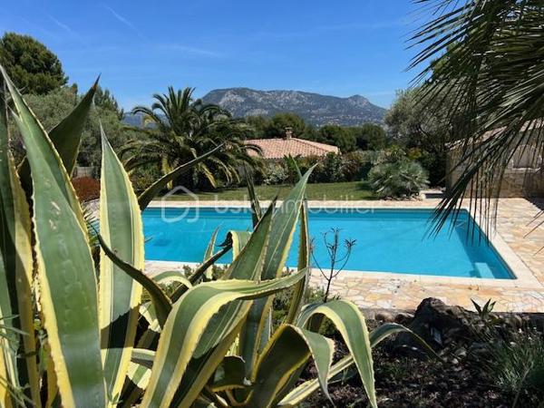 Découvrez cette propriété d’exception où élégance, volumes et douceur de vivre se rencontrent dans un cadre privilégié.

Édifiée sur un magnifique terrain de 3 939 m², cette villa de prestige développe près de 240 m² habitables, répartis entre une villa principale de plain-pied de 160 m² et une dépendance indépendante de 80 m². Un lieu pensé pour ceux qui recherchent espace, confort et sérénité, avec une vue dégagée remarquable sur les montagnes, la ville et la mer.

Dès l’entrée, la lumière s’invite naturellement grâce aux larges baies vitrées qui habillent le spacieux séjour et prolongent les espaces vers une terrasse généreuse et un jardin soigneusement aménagé. Son exposition Sud-Est sublime chaque instant de la journée.

Le salon s’ouvre harmonieusement sur une cuisine moderne, entièrement équipée et ouverte sur l’espace de vie.

L’espace nuit propose trois belles chambres, dont une superbe suite parentale avec dressing et salle de bain privative, complétées par une salle d’eau, deux WC, une buanderie ainsi qu’un bureau donnant accès au garage.

Au niveau inférieur, une dépendance indépendante de 80 m² offre de nombreuses possibilités : recevoir famille et amis, activité professionnelle ou investissement locatif. Elle se compose d’un vaste séjour avec cheminée et cuisine américaine, d’une suite parentale avec salle d’eau et rangements, ainsi que d’un accès à une cave et un espace extérieur de stockage.

Les extérieurs ont été pensés comme une véritable invitation à la détente : une grande piscine 12 x 6, un élégant pool house avec cuisine d’été, douche, WC et local technique, plusieurs espaces de repos, un terrain de pétanque et de vastes espaces verts.

Deux garages ainsi que de nombreux stationnements complètent ce bien rare.

Prestations supplémentaires : classement énergétique A, panneaux solaires, arrosage automatique, goutte-à-goutte, fosse septique, cuve à gaz, eau du Canal de Provence.

Un lieu où les réveils commencent avec une vue inspirante et où les journées semblent toujours avoir un parfum de vacances.

Un véritable havre de paix à découvrir sans tarder.