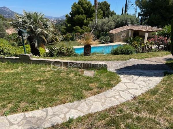 Découvrez cette propriété d’exception où élégance, volumes et douceur de vivre se rencontrent dans un cadre privilégié.

Édifiée sur un magnifique terrain de 3 939 m², cette villa de prestige développe près de 240 m² habitables, répartis entre une villa principale de plain-pied de 160 m² et une dépendance indépendante de 80 m². Un lieu pensé pour ceux qui recherchent espace, confort et sérénité, avec une vue dégagée remarquable sur les montagnes, la ville et la mer.

Dès l’entrée, la lumière s’invite naturellement grâce aux larges baies vitrées qui habillent le spacieux séjour et prolongent les espaces vers une terrasse généreuse et un jardin soigneusement aménagé. Son exposition Sud-Est sublime chaque instant de la journée.

Le salon s’ouvre harmonieusement sur une cuisine moderne, entièrement équipée et ouverte sur l’espace de vie.

L’espace nuit propose trois belles chambres, dont une superbe suite parentale avec dressing et salle de bain privative, complétées par une salle d’eau, deux WC, une buanderie ainsi qu’un bureau donnant accès au garage.

Au niveau inférieur, une dépendance indépendante de 80 m² offre de nombreuses possibilités : recevoir famille et amis, activité professionnelle ou investissement locatif. Elle se compose d’un vaste séjour avec cheminée et cuisine américaine, d’une suite parentale avec salle d’eau et rangements, ainsi que d’un accès à une cave et un espace extérieur de stockage.

Les extérieurs ont été pensés comme une véritable invitation à la détente : une grande piscine 12 x 6, un élégant pool house avec cuisine d’été, douche, WC et local technique, plusieurs espaces de repos, un terrain de pétanque et de vastes espaces verts.

Deux garages ainsi que de nombreux stationnements complètent ce bien rare.

Prestations supplémentaires : classement énergétique A, panneaux solaires, arrosage automatique, goutte-à-goutte, fosse septique, cuve à gaz, eau du Canal de Provence.

Un lieu où les réveils commencent avec une vue inspirante et où les journées semblent toujours avoir un parfum de vacances.

Un véritable havre de paix à découvrir sans tarder.