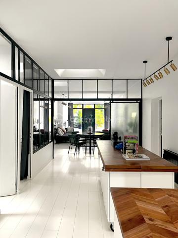 Située dans le quartier Signac – Murs à Pêches à Montreuil, au cœur d’un environnement verdoyant et préservé, cette maison de plain-pied d’environ 223 m² incarne un esprit loft industriel rare, mêlant volumes exceptionnels, lumière naturelle omniprésente et prestations haut de gamme.

Entièrement repensée par un architecte-designer il y a six ans, elle a bénéficié d’une rénovation complète avec des matériaux de qualité, une isolation performante et une attention particulière portée aux finitions. Verrières industrielles, puits de lumière et ouvertures généreuses confèrent à l’ensemble une atmosphère à la fois contemporaine et chaleureuse.

La pièce de vie, d’environ 130 m², constitue le cœur de la maison. Elle réunit une entrée / séjour lumineux, une salle à manger conviviale, une cuisine ouverte sur un salon avec cheminée moderne. L’ensemble s’ouvre largement sur un jardin arboré, offrant un cadre de vie paisible et verdoyant.
Une surprise vous attend avec la découverte d'un espace détente de 15m² révélant une piscine intérieure chauffée et d'une profondeur d'1m30 ! (traitement au sel, VMC dédiée).

L'espace nuit, comprends trois chambres aux volumes généreux et rangements intégrés, deux salles d’eau, dont une grande salle de bains avec baignoire et douche hammam, un dressing indépendant et un emplacement de stockage.

Deux grandes terrasses (avant et arrière) complètent l'ensemble, ainsi que deux emplacements de stationnement avec possibilité de borne de recharge électrique.
Alarme
Isolation performante et rénovation récente
Garantie décennale
Triple vitrage
Très bon DPE : B et GES : A

Enorme potentiel d'agrandissement avec la possibilité de surélévation permettant un gain d’environ 150 m² supplémentaires (sous réserves des autorisations d'usage).

Un bien d’exception alliant charme, confort, modernité et fort potentiel d’évolution, dans un environnement privilégié aux portes de Paris.

Ligne 9 : Mairie de Montreuil à 900m
Parc des Beaumonts à 700m
