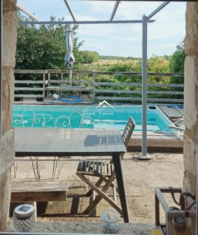 Vue sur la piscine avec la terrasse et sur la campagne
