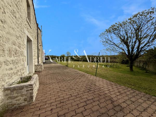 Maison en pierre rénovée offrant 3 chambres, jardin, dépendances et garage