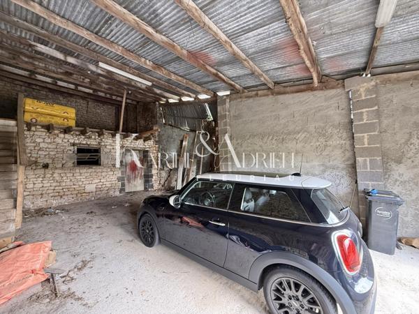 Maison en pierre rénovée offrant 3 chambres, jardin, dépendances et garage