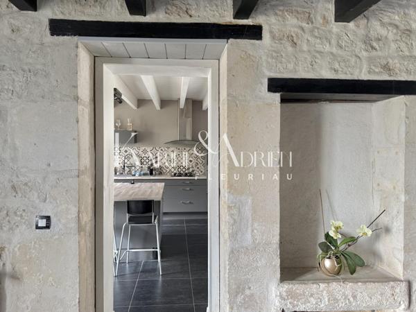 Maison en pierre rénovée offrant 3 chambres, jardin, dépendances et garage