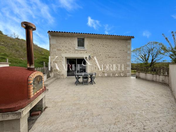 Maison en pierre rénovée offrant 3 chambres, jardin, dépendances et garage