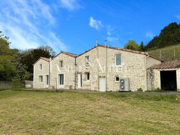 Maison en pierre rénovée offrant 3 chambres, jardin, dépendances et garage