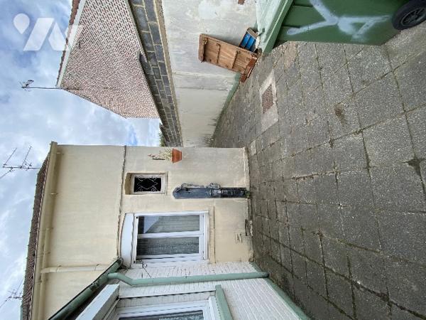 Maison de ville avec passage latéral étroit, garage, jardin et dépendances