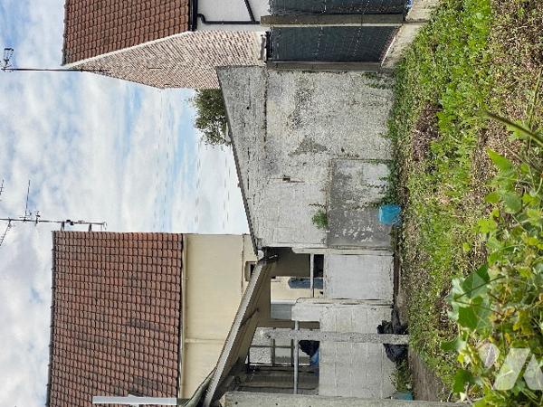 Maison de ville avec passage latéral étroit, garage, jardin et dépendances