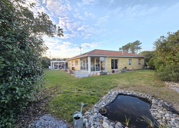 Située au cœur du très recherché lotissement communal de Mouncaout, cette élégante maison contemporaine construite en 2014 vous séduira par la qualité de ses prestations, sa luminosité et son excellent niveau de confort énergétique.

Implantée sur une parcelle de 865 m², la maison principale offre une belle pièce de vie traversante d’environ 47 m², baignée de lumière, avec cuisine ouverte entièrement équipée. L’espace nuit se compose de trois chambres avec placards intégrés, d’une salle de bains complète avec douche, ainsi que de WC séparés. L’agencement est fonctionnel et parfaitement adapté à une vie de famille.

Côté prestations, tout a été pensé pour allier confort et économies d’énergie : climatisation réversible, poêle à granulés récent (2023), installation photovoltaïque de 3 kW, ainsi qu’un cumulus thermodynamique. Une véranda réalisée en 2018 et une agréable terrasse viennent compléter les espaces de vie.

À l’extérieur, vous bénéficierez d’un grand garage de 34 m², récent, avec triple accès motorisé, entièrement carrelé et équipé d’une cuisine d’été, idéal pour recevoir.

Un véritable atout supplémentaire : un appartement T2 indépendant, conforme aux normes PMR et réalisé en 2023. Il dispose de sa propre pièce de vie avec cuisine, d’une salle d’eau, d’un cellier, d’un cumulus indépendant et d’un accès privatif. Parfait pour un projet locatif, une activité professionnelle ou pour accueillir famille et amis en toute autonomie.

Dans un environnement calme, tout en étant à proximité immédiate des commodités, cette propriété complète, modulable et particulièrement économique représente une opportunité rare sur le secteur.

Un bien clé en main, idéal pour une résidence principale avec revenu complémentaire ou projet familial évolutif.