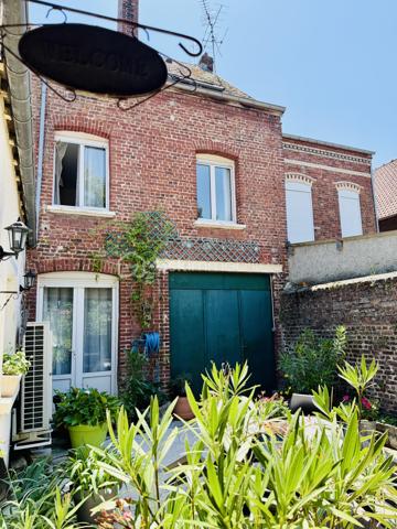 Une maison pour ceux qui veulent une vraie adresse, une vraie façade, une vraie cour, de vraies chambres, et cette impression assez rare aujourd’hui : pouvoir accueillir large, vivre grand, et rester proche de tout.

On imagine très vite les grandes tablées, les enfants qui montent et descendent l’escalier, les courses que l’on décharge directement du garage à la cuisine, les repas dehors, les étés au calme, les chambres pleines et les dimanches qui s’étirent.

Rue Hoche, à Albert, cette maison individuelle d’environ 212 m² offre un équilibre rare : une vraie maison de ville, proche de tout, avec l’espace d’une grande maison familiale, une cour intime (80m2) tournée vers la rivière l’Ancre, un garage profond et 8 chambres ! 

Derrière sa façade en brique, solide et pleine de caractère, la maison dévoile des volumes généreux et une organisation pensée pour la vie quotidienne. Ici, on ne manque pas de place. Les pièces de réception permettent de recevoir, de dresser de grandes tables, de vivre ensemble sans se marcher dessus. La salle à manger et le salon conservent une atmosphère chaleureuse, avec de beaux détails, une cheminée, des rangements intégrés et cette âme que les maisons anciennes savent garder mieux que personne.

La cuisine est l’un des vrais cœurs de la maison. Spacieuse, conviviale, tournée vers la cour, elle offre aussi une vue rare et presque inattendue sur la Vierge de la Basilique. Un détail que l’on ne peut pas inventer, et que l’on apprécie chaque jour, sans même s’en rendre compte.

Côté pratique, le garage est un véritable atout. Profond, équipé d’une porte électrique, il permet d’accéder directement à la cour puis à la cuisine : les courses, les sacs, les vélos, les outils, tout devient plus simple. Un vrai confort de maison familiale, surtout en centre-ville.

À l’arrière, la cour change complètement l’ambiance. Calme, verdoyante, protégée des regards, elle donne sur la rivière l’Ancre. Sous la partie abritée, on accède à cet espace plus intime encore, avec établi, stockage et de nombreuses possibilités : atelier, cuisine d’été, coin bricolage, espace jacuzzi, salon extérieur couvert… chacun pourra y projeter son mode de vie.

La maison compte 8 chambres, ce qui ouvre de multiples usages : grande famille, famille recomposée, chambres d’amis, bureaux, espace ado, activité indépendante, hébergement ponctuel, location chambres meublées ou projet intergénérationnel. Chacun peut avoir sa place, et c’est suffisamment rare pour être souligné.

L’emplacement est un autre point fort. Rue Hoche, à Albert, les écoles sont accessibles à pied en environ 5 minutes, tout comme les commerces. On profite d’un quotidien simple, central, sans dépendre systématiquement de la voiture, tout en conservant les avantages d’une maison avec garage, cour et volumes.

Côté technique, la maison bénéficie d’un classement énergétique confortable pour une bâtisse ancienne : DPE C et GES A. Le chauffage est assuré principalement par une pompe à chaleur air/eau, avec insert bois en appoint. L’eau chaude est produite par un chauffe-eau thermodynamique complété par un ballon électrique. 
+ grande cave et grenier 
.
C’est une maison qui a de la place, du caractère, du pratique, du vivant.
