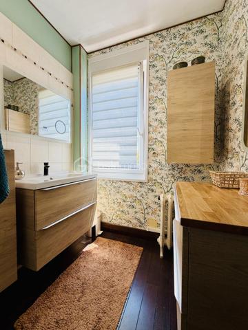 Une maison pour ceux qui veulent une vraie adresse, une vraie façade, une vraie cour, de vraies chambres, et cette impression assez rare aujourd’hui : pouvoir accueillir large, vivre grand, et rester proche de tout.

On imagine très vite les grandes tablées, les enfants qui montent et descendent l’escalier, les courses que l’on décharge directement du garage à la cuisine, les repas dehors, les étés au calme, les chambres pleines et les dimanches qui s’étirent.

Rue Hoche, à Albert, cette maison individuelle d’environ 212 m² offre un équilibre rare : une vraie maison de ville, proche de tout, avec l’espace d’une grande maison familiale, une cour intime (80m2) tournée vers la rivière l’Ancre, un garage profond et 8 chambres ! 

Derrière sa façade en brique, solide et pleine de caractère, la maison dévoile des volumes généreux et une organisation pensée pour la vie quotidienne. Ici, on ne manque pas de place. Les pièces de réception permettent de recevoir, de dresser de grandes tables, de vivre ensemble sans se marcher dessus. La salle à manger et le salon conservent une atmosphère chaleureuse, avec de beaux détails, une cheminée, des rangements intégrés et cette âme que les maisons anciennes savent garder mieux que personne.

La cuisine est l’un des vrais cœurs de la maison. Spacieuse, conviviale, tournée vers la cour, elle offre aussi une vue rare et presque inattendue sur la Vierge de la Basilique. Un détail que l’on ne peut pas inventer, et que l’on apprécie chaque jour, sans même s’en rendre compte.

Côté pratique, le garage est un véritable atout. Profond, équipé d’une porte électrique, il permet d’accéder directement à la cour puis à la cuisine : les courses, les sacs, les vélos, les outils, tout devient plus simple. Un vrai confort de maison familiale, surtout en centre-ville.

À l’arrière, la cour change complètement l’ambiance. Calme, verdoyante, protégée des regards, elle donne sur la rivière l’Ancre. Sous la partie abritée, on accède à cet espace plus intime encore, avec établi, stockage et de nombreuses possibilités : atelier, cuisine d’été, coin bricolage, espace jacuzzi, salon extérieur couvert… chacun pourra y projeter son mode de vie.

La maison compte 8 chambres, ce qui ouvre de multiples usages : grande famille, famille recomposée, chambres d’amis, bureaux, espace ado, activité indépendante, hébergement ponctuel, location chambres meublées ou projet intergénérationnel. Chacun peut avoir sa place, et c’est suffisamment rare pour être souligné.

L’emplacement est un autre point fort. Rue Hoche, à Albert, les écoles sont accessibles à pied en environ 5 minutes, tout comme les commerces. On profite d’un quotidien simple, central, sans dépendre systématiquement de la voiture, tout en conservant les avantages d’une maison avec garage, cour et volumes.

Côté technique, la maison bénéficie d’un classement énergétique confortable pour une bâtisse ancienne : DPE C et GES A. Le chauffage est assuré principalement par une pompe à chaleur air/eau, avec insert bois en appoint. L’eau chaude est produite par un chauffe-eau thermodynamique complété par un ballon électrique. 
+ grande cave et grenier 
.
C’est une maison qui a de la place, du caractère, du pratique, du vivant.