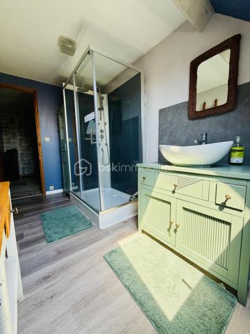Une maison pour ceux qui veulent une vraie adresse, une vraie façade, une vraie cour, de vraies chambres, et cette impression assez rare aujourd’hui : pouvoir accueillir large, vivre grand, et rester proche de tout.

On imagine très vite les grandes tablées, les enfants qui montent et descendent l’escalier, les courses que l’on décharge directement du garage à la cuisine, les repas dehors, les étés au calme, les chambres pleines et les dimanches qui s’étirent.

Rue Hoche, à Albert, cette maison individuelle d’environ 212 m² offre un équilibre rare : une vraie maison de ville, proche de tout, avec l’espace d’une grande maison familiale, une cour intime (80m2) tournée vers la rivière l’Ancre, un garage profond et 8 chambres ! 

Derrière sa façade en brique, solide et pleine de caractère, la maison dévoile des volumes généreux et une organisation pensée pour la vie quotidienne. Ici, on ne manque pas de place. Les pièces de réception permettent de recevoir, de dresser de grandes tables, de vivre ensemble sans se marcher dessus. La salle à manger et le salon conservent une atmosphère chaleureuse, avec de beaux détails, une cheminée, des rangements intégrés et cette âme que les maisons anciennes savent garder mieux que personne.

La cuisine est l’un des vrais cœurs de la maison. Spacieuse, conviviale, tournée vers la cour, elle offre aussi une vue rare et presque inattendue sur la Vierge de la Basilique. Un détail que l’on ne peut pas inventer, et que l’on apprécie chaque jour, sans même s’en rendre compte.

Côté pratique, le garage est un véritable atout. Profond, équipé d’une porte électrique, il permet d’accéder directement à la cour puis à la cuisine : les courses, les sacs, les vélos, les outils, tout devient plus simple. Un vrai confort de maison familiale, surtout en centre-ville.

À l’arrière, la cour change complètement l’ambiance. Calme, verdoyante, protégée des regards, elle donne sur la rivière l’Ancre. Sous la partie abritée, on accède à cet espace plus intime encore, avec établi, stockage et de nombreuses possibilités : atelier, cuisine d’été, coin bricolage, espace jacuzzi, salon extérieur couvert… chacun pourra y projeter son mode de vie.

La maison compte 8 chambres, ce qui ouvre de multiples usages : grande famille, famille recomposée, chambres d’amis, bureaux, espace ado, activité indépendante, hébergement ponctuel, location chambres meublées ou projet intergénérationnel. Chacun peut avoir sa place, et c’est suffisamment rare pour être souligné.

L’emplacement est un autre point fort. Rue Hoche, à Albert, les écoles sont accessibles à pied en environ 5 minutes, tout comme les commerces. On profite d’un quotidien simple, central, sans dépendre systématiquement de la voiture, tout en conservant les avantages d’une maison avec garage, cour et volumes.

Côté technique, la maison bénéficie d’un classement énergétique confortable pour une bâtisse ancienne : DPE C et GES A. Le chauffage est assuré principalement par une pompe à chaleur air/eau, avec insert bois en appoint. L’eau chaude est produite par un chauffe-eau thermodynamique complété par un ballon électrique. 
+ grande cave et grenier 
.
C’est une maison qui a de la place, du caractère, du pratique, du vivant.