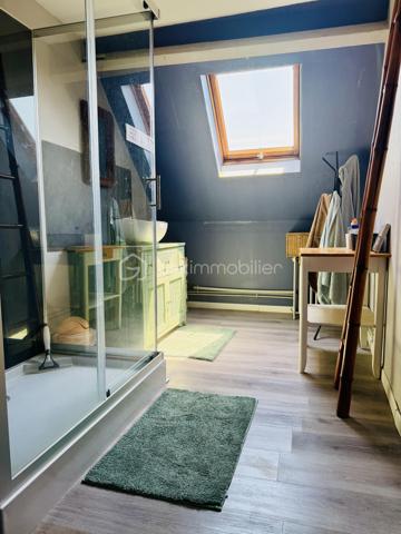 Une maison pour ceux qui veulent une vraie adresse, une vraie façade, une vraie cour, de vraies chambres, et cette impression assez rare aujourd’hui : pouvoir accueillir large, vivre grand, et rester proche de tout.

On imagine très vite les grandes tablées, les enfants qui montent et descendent l’escalier, les courses que l’on décharge directement du garage à la cuisine, les repas dehors, les étés au calme, les chambres pleines et les dimanches qui s’étirent.

Rue Hoche, à Albert, cette maison individuelle d’environ 212 m² offre un équilibre rare : une vraie maison de ville, proche de tout, avec l’espace d’une grande maison familiale, une cour intime (80m2) tournée vers la rivière l’Ancre, un garage profond et 8 chambres ! 

Derrière sa façade en brique, solide et pleine de caractère, la maison dévoile des volumes généreux et une organisation pensée pour la vie quotidienne. Ici, on ne manque pas de place. Les pièces de réception permettent de recevoir, de dresser de grandes tables, de vivre ensemble sans se marcher dessus. La salle à manger et le salon conservent une atmosphère chaleureuse, avec de beaux détails, une cheminée, des rangements intégrés et cette âme que les maisons anciennes savent garder mieux que personne.

La cuisine est l’un des vrais cœurs de la maison. Spacieuse, conviviale, tournée vers la cour, elle offre aussi une vue rare et presque inattendue sur la Vierge de la Basilique. Un détail que l’on ne peut pas inventer, et que l’on apprécie chaque jour, sans même s’en rendre compte.

Côté pratique, le garage est un véritable atout. Profond, équipé d’une porte électrique, il permet d’accéder directement à la cour puis à la cuisine : les courses, les sacs, les vélos, les outils, tout devient plus simple. Un vrai confort de maison familiale, surtout en centre-ville.

À l’arrière, la cour change complètement l’ambiance. Calme, verdoyante, protégée des regards, elle donne sur la rivière l’Ancre. Sous la partie abritée, on accède à cet espace plus intime encore, avec établi, stockage et de nombreuses possibilités : atelier, cuisine d’été, coin bricolage, espace jacuzzi, salon extérieur couvert… chacun pourra y projeter son mode de vie.

La maison compte 8 chambres, ce qui ouvre de multiples usages : grande famille, famille recomposée, chambres d’amis, bureaux, espace ado, activité indépendante, hébergement ponctuel, location chambres meublées ou projet intergénérationnel. Chacun peut avoir sa place, et c’est suffisamment rare pour être souligné.

L’emplacement est un autre point fort. Rue Hoche, à Albert, les écoles sont accessibles à pied en environ 5 minutes, tout comme les commerces. On profite d’un quotidien simple, central, sans dépendre systématiquement de la voiture, tout en conservant les avantages d’une maison avec garage, cour et volumes.

Côté technique, la maison bénéficie d’un classement énergétique confortable pour une bâtisse ancienne : DPE C et GES A. Le chauffage est assuré principalement par une pompe à chaleur air/eau, avec insert bois en appoint. L’eau chaude est produite par un chauffe-eau thermodynamique complété par un ballon électrique. 
+ grande cave et grenier 
.
C’est une maison qui a de la place, du caractère, du pratique, du vivant.