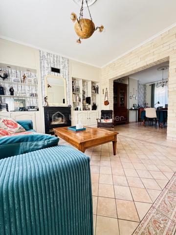 Une maison pour ceux qui veulent une vraie adresse, une vraie façade, une vraie cour, de vraies chambres, et cette impression assez rare aujourd’hui : pouvoir accueillir large, vivre grand, et rester proche de tout.

On imagine très vite les grandes tablées, les enfants qui montent et descendent l’escalier, les courses que l’on décharge directement du garage à la cuisine, les repas dehors, les étés au calme, les chambres pleines et les dimanches qui s’étirent.

Rue Hoche, à Albert, cette maison individuelle d’environ 212 m² offre un équilibre rare : une vraie maison de ville, proche de tout, avec l’espace d’une grande maison familiale, une cour intime (80m2) tournée vers la rivière l’Ancre, un garage profond et 8 chambres ! 

Derrière sa façade en brique, solide et pleine de caractère, la maison dévoile des volumes généreux et une organisation pensée pour la vie quotidienne. Ici, on ne manque pas de place. Les pièces de réception permettent de recevoir, de dresser de grandes tables, de vivre ensemble sans se marcher dessus. La salle à manger et le salon conservent une atmosphère chaleureuse, avec de beaux détails, une cheminée, des rangements intégrés et cette âme que les maisons anciennes savent garder mieux que personne.

La cuisine est l’un des vrais cœurs de la maison. Spacieuse, conviviale, tournée vers la cour, elle offre aussi une vue rare et presque inattendue sur la Vierge de la Basilique. Un détail que l’on ne peut pas inventer, et que l’on apprécie chaque jour, sans même s’en rendre compte.

Côté pratique, le garage est un véritable atout. Profond, équipé d’une porte électrique, il permet d’accéder directement à la cour puis à la cuisine : les courses, les sacs, les vélos, les outils, tout devient plus simple. Un vrai confort de maison familiale, surtout en centre-ville.

À l’arrière, la cour change complètement l’ambiance. Calme, verdoyante, protégée des regards, elle donne sur la rivière l’Ancre. Sous la partie abritée, on accède à cet espace plus intime encore, avec établi, stockage et de nombreuses possibilités : atelier, cuisine d’été, coin bricolage, espace jacuzzi, salon extérieur couvert… chacun pourra y projeter son mode de vie.

La maison compte 8 chambres, ce qui ouvre de multiples usages : grande famille, famille recomposée, chambres d’amis, bureaux, espace ado, activité indépendante, hébergement ponctuel, location chambres meublées ou projet intergénérationnel. Chacun peut avoir sa place, et c’est suffisamment rare pour être souligné.

L’emplacement est un autre point fort. Rue Hoche, à Albert, les écoles sont accessibles à pied en environ 5 minutes, tout comme les commerces. On profite d’un quotidien simple, central, sans dépendre systématiquement de la voiture, tout en conservant les avantages d’une maison avec garage, cour et volumes.

Côté technique, la maison bénéficie d’un classement énergétique confortable pour une bâtisse ancienne : DPE C et GES A. Le chauffage est assuré principalement par une pompe à chaleur air/eau, avec insert bois en appoint. L’eau chaude est produite par un chauffe-eau thermodynamique complété par un ballon électrique. 
+ grande cave et grenier 
.
C’est une maison qui a de la place, du caractère, du pratique, du vivant.