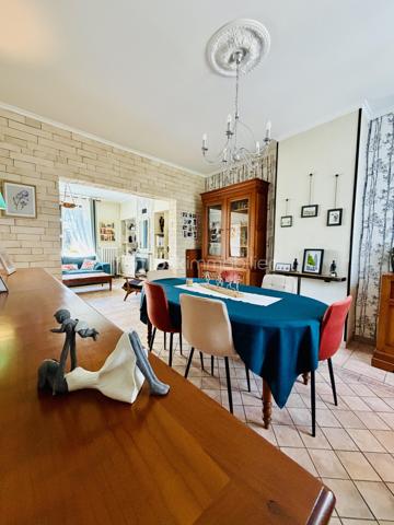 Une maison pour ceux qui veulent une vraie adresse, une vraie façade, une vraie cour, de vraies chambres, et cette impression assez rare aujourd’hui : pouvoir accueillir large, vivre grand, et rester proche de tout.

On imagine très vite les grandes tablées, les enfants qui montent et descendent l’escalier, les courses que l’on décharge directement du garage à la cuisine, les repas dehors, les étés au calme, les chambres pleines et les dimanches qui s’étirent.

Rue Hoche, à Albert, cette maison individuelle d’environ 212 m² offre un équilibre rare : une vraie maison de ville, proche de tout, avec l’espace d’une grande maison familiale, une cour intime (80m2) tournée vers la rivière l’Ancre, un garage profond et 8 chambres ! 

Derrière sa façade en brique, solide et pleine de caractère, la maison dévoile des volumes généreux et une organisation pensée pour la vie quotidienne. Ici, on ne manque pas de place. Les pièces de réception permettent de recevoir, de dresser de grandes tables, de vivre ensemble sans se marcher dessus. La salle à manger et le salon conservent une atmosphère chaleureuse, avec de beaux détails, une cheminée, des rangements intégrés et cette âme que les maisons anciennes savent garder mieux que personne.

La cuisine est l’un des vrais cœurs de la maison. Spacieuse, conviviale, tournée vers la cour, elle offre aussi une vue rare et presque inattendue sur la Vierge de la Basilique. Un détail que l’on ne peut pas inventer, et que l’on apprécie chaque jour, sans même s’en rendre compte.

Côté pratique, le garage est un véritable atout. Profond, équipé d’une porte électrique, il permet d’accéder directement à la cour puis à la cuisine : les courses, les sacs, les vélos, les outils, tout devient plus simple. Un vrai confort de maison familiale, surtout en centre-ville.

À l’arrière, la cour change complètement l’ambiance. Calme, verdoyante, protégée des regards, elle donne sur la rivière l’Ancre. Sous la partie abritée, on accède à cet espace plus intime encore, avec établi, stockage et de nombreuses possibilités : atelier, cuisine d’été, coin bricolage, espace jacuzzi, salon extérieur couvert… chacun pourra y projeter son mode de vie.

La maison compte 8 chambres, ce qui ouvre de multiples usages : grande famille, famille recomposée, chambres d’amis, bureaux, espace ado, activité indépendante, hébergement ponctuel, location chambres meublées ou projet intergénérationnel. Chacun peut avoir sa place, et c’est suffisamment rare pour être souligné.

L’emplacement est un autre point fort. Rue Hoche, à Albert, les écoles sont accessibles à pied en environ 5 minutes, tout comme les commerces. On profite d’un quotidien simple, central, sans dépendre systématiquement de la voiture, tout en conservant les avantages d’une maison avec garage, cour et volumes.

Côté technique, la maison bénéficie d’un classement énergétique confortable pour une bâtisse ancienne : DPE C et GES A. Le chauffage est assuré principalement par une pompe à chaleur air/eau, avec insert bois en appoint. L’eau chaude est produite par un chauffe-eau thermodynamique complété par un ballon électrique. 
+ grande cave et grenier 
.
C’est une maison qui a de la place, du caractère, du pratique, du vivant.