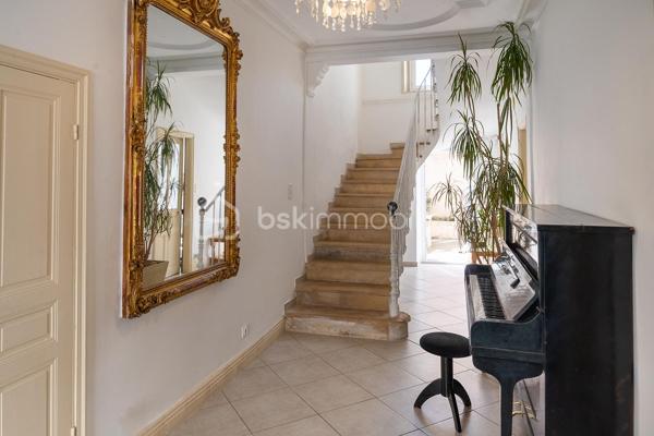 Vous recherchez une demeure de caractère alliant le charme de l'ancien au confort d'aujourd'hui ? Cette magnifique maison de ville bourgeoise, saura vous séduire par ses volumes généreux, sa luminosité et la qualité de ses prestations.

Dès l'entrée, le charme opère. Un superbe escalier en pierre, sublimé par une élégante rampe en fer forgé, donne le ton et confère à cette demeure une atmosphère raffinée et intemporelle.

Le rez-de-chaussée accueille un vaste double séjour baigné de lumière, offrant un espace de vie convivial et chaleureux, idéal pour recevoir famille et amis.

La grande cuisine entièrement aménagée et équipée s'ouvre sur un agréable patio intérieur, véritable cocon de tranquillité à l'abri des regards. Un espace privilégié pour partager des repas en extérieur ou profiter d'un moment de détente en toute saison.

À l'étage, le palier dessert quatre belles chambres aux volumes confortables, dont une superbe suite parentale de plus de 25 m² avec un espace dressing indépendant à aménager selon vos envies.

La salle de bains, d'une superficie exceptionnelle de 15 m², offre un véritable espace bien-être avec baignoire balnéo, douche, double vasque et WC.

Une salle d'eau avec WC, séduira les familles comme les personnes souhaitant accueillir leurs proches dans les meilleures conditions.

Au dernier niveau, un grenier de plus de 80 m², bénéficiant d'une belle hauteur sous plafond et d'ouvertures existantes, offre un potentiel remarquable. Vous pourrez y créer une suite parentale supplémentaire, une salle de jeux, un espace cinéma, un bureau, un atelier ou encore un appartement indépendant.

Les atouts qui font toute la différence :

✔ Garage de 23 m²
✔ Patio intimiste et ensoleillé
✔ Buanderie
✔ Nombreux espaces de rangement
✔ Maison en très bon état
✔ Cachet de l'ancien préservé

Un emplacement pratique au quotidien

Située à proximité immédiate de toutes les commodités :

Commerces alimentaires : 100 m
Pharmacie : 300 m
Boulangerie : 400 m
École maternelle : 500 m
École primaire : 600 m
Collège : 1 km

> Une localisation idéale pour une vie de famille sereine, avec tous les services accessibles à pied.

> Une maison qui invite à se projeter

> Une propriété rare sur le marché, idéale pour les amoureux des belles maisons, à la recherche d'un bien de caractère offrant de beaux volumes, des prestations de qualité et un fort potentiel d'évolution.

Une visite s'impose pour découvrir tout son charme.