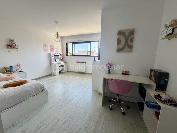 Située dans un cadre privilégié, en lot arrière, à l’abri des regards, cette remarquable maison contemporaine de 208 m² érigée en 2021 sur une parcelle de 951 m² vous offre un cadre de vie d’exception alliant confort absolu, prestations haut de gamme et tranquillité.

Toutes les commodités — écoles, commerces, transports — sont accessibles à moins de 10 minutes à pied, un atout rare qui conjugue vie au vert et praticité du quotidien.

LE REZ-DE-CHAUSSÉE:
Dès l’entrée, vous serez saisi par le volume exceptionnel du séjour triple baigné de lumière, de plus de 70 m², orienté Est-Ouest, ouvert sur le jardin et sa piscine. La cuisine américaine, entièrement aménagée et équipée, s’intègre avec élégance dans cet espace de vie généreux, idéal pour recevoir.

Le rez-de-chaussée comprend également :
	•	Une suite parentale de 28 m² avec dressing, salle de bains dotée d’une douche à l’italienne et d’une baignoire balnéo — un véritable espace bien-être privatif
	•	Un cellier
	•	Un WC suspendu indépendant
	•	Un double garage de 45 m² avec coin buanderie et mezzanine de 28 m² utiles, offrant un potentiel d’aménagement supplémentaire considérable

L’ÉTAGE:
L’étage est dédié au repos et à l’intimité de chacun. Il se compose de :
	•	3 suites de 28 m² chacune, toutes dotées d’un dressing et desservies par 1 salle de bains et 2 salles d’eau
	•	1 chambre d’amis de 15 m²
	•	Un WC suspendu indépendant

Une configuration idéale pour les familles nombreuses ou pour accueillir les proches dans les meilleures conditions.

LES EXTÉRIEURS:
L’extérieur est à la hauteur de l’intérieur. Une allée de 250 m² dessert la propriété et offre de nombreuses places de stationnement, complétées par des emplacements libres dans la rue.

Le terrain d’environ 700 m² accueille :
	•	Une terrasse de 40 m², parfaite pour les beaux jours
	•	Une piscine 8 x 3,5 m avec plage, chauffée par pompe à chaleur, équipée d’un volet électrique et d’un local technique dédié

LES ATOUTS TECHNIQUES:
Cette maison a été construite avec des matériaux de qualité supérieure et bénéficie de toutes les garanties :

	•	✅ Garantie décennale & dommages-ouvrage (construction 2021)
	•	✅ Construction en briques et escalier béton
	•	✅ Chauffage au sol par pompe à chaleur géothermique, complété par des radiateurs au gaz
	•	✅ Ballon thermodynamique
	•	✅ Norme RT 2012 — performance énergétique maîtrisée
	•	✅ 2 puisards pour une gestion optimale des eaux

Une propriété rare, clé en main, sans aucun travaux à prévoir. À visiter absolument.

Prix de vente : 800 000 €

Visite virtuelle disponible très prochainement ! 

Conseillère disponible 7j/7.
📞 Contactez-moi dès maintenant pour programmer votre visite.