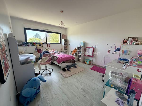 Située dans un cadre privilégié, en lot arrière, à l’abri des regards, cette remarquable maison contemporaine de 208 m² érigée en 2021 sur une parcelle de 951 m² vous offre un cadre de vie d’exception alliant confort absolu, prestations haut de gamme et tranquillité.

Toutes les commodités — écoles, commerces, transports — sont accessibles à moins de 10 minutes à pied, un atout rare qui conjugue vie au vert et praticité du quotidien.

LE REZ-DE-CHAUSSÉE:
Dès l’entrée, vous serez saisi par le volume exceptionnel du séjour triple baigné de lumière, de plus de 70 m², orienté Est-Ouest, ouvert sur le jardin et sa piscine. La cuisine américaine, entièrement aménagée et équipée, s’intègre avec élégance dans cet espace de vie généreux, idéal pour recevoir.

Le rez-de-chaussée comprend également :
	•	Une suite parentale de 28 m² avec dressing, salle de bains dotée d’une douche à l’italienne et d’une baignoire balnéo — un véritable espace bien-être privatif
	•	Un cellier
	•	Un WC suspendu indépendant
	•	Un double garage de 45 m² avec coin buanderie et mezzanine de 28 m² utiles, offrant un potentiel d’aménagement supplémentaire considérable

L’ÉTAGE:
L’étage est dédié au repos et à l’intimité de chacun. Il se compose de :
	•	3 suites de 28 m² chacune, toutes dotées d’un dressing et desservies par 1 salle de bains et 2 salles d’eau
	•	1 chambre d’amis de 15 m²
	•	Un WC suspendu indépendant

Une configuration idéale pour les familles nombreuses ou pour accueillir les proches dans les meilleures conditions.

LES EXTÉRIEURS:
L’extérieur est à la hauteur de l’intérieur. Une allée de 250 m² dessert la propriété et offre de nombreuses places de stationnement, complétées par des emplacements libres dans la rue.

Le terrain d’environ 700 m² accueille :
	•	Une terrasse de 40 m², parfaite pour les beaux jours
	•	Une piscine 8 x 3,5 m avec plage, chauffée par pompe à chaleur, équipée d’un volet électrique et d’un local technique dédié

LES ATOUTS TECHNIQUES:
Cette maison a été construite avec des matériaux de qualité supérieure et bénéficie de toutes les garanties :

	•	✅ Garantie décennale & dommages-ouvrage (construction 2021)
	•	✅ Construction en briques et escalier béton
	•	✅ Chauffage au sol par pompe à chaleur géothermique, complété par des radiateurs au gaz
	•	✅ Ballon thermodynamique
	•	✅ Norme RT 2012 — performance énergétique maîtrisée
	•	✅ 2 puisards pour une gestion optimale des eaux

Une propriété rare, clé en main, sans aucun travaux à prévoir. À visiter absolument.

Prix de vente : 800 000 €

Visite virtuelle disponible très prochainement ! 

Conseillère disponible 7j/7.
📞 Contactez-moi dès maintenant pour programmer votre visite.