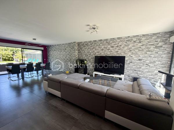 Située dans un cadre privilégié, en lot arrière, à l’abri des regards, cette remarquable maison contemporaine de 208 m² érigée en 2021 sur une parcelle de 951 m² vous offre un cadre de vie d’exception alliant confort absolu, prestations haut de gamme et tranquillité.

Toutes les commodités — écoles, commerces, transports — sont accessibles à moins de 10 minutes à pied, un atout rare qui conjugue vie au vert et praticité du quotidien.

LE REZ-DE-CHAUSSÉE:
Dès l’entrée, vous serez saisi par le volume exceptionnel du séjour triple baigné de lumière, de plus de 70 m², orienté Est-Ouest, ouvert sur le jardin et sa piscine. La cuisine américaine, entièrement aménagée et équipée, s’intègre avec élégance dans cet espace de vie généreux, idéal pour recevoir.

Le rez-de-chaussée comprend également :
	•	Une suite parentale de 28 m² avec dressing, salle de bains dotée d’une douche à l’italienne et d’une baignoire balnéo — un véritable espace bien-être privatif
	•	Un cellier
	•	Un WC suspendu indépendant
	•	Un double garage de 45 m² avec coin buanderie et mezzanine de 28 m² utiles, offrant un potentiel d’aménagement supplémentaire considérable

L’ÉTAGE:
L’étage est dédié au repos et à l’intimité de chacun. Il se compose de :
	•	3 suites de 28 m² chacune, toutes dotées d’un dressing et desservies par 1 salle de bains et 2 salles d’eau
	•	1 chambre d’amis de 15 m²
	•	Un WC suspendu indépendant

Une configuration idéale pour les familles nombreuses ou pour accueillir les proches dans les meilleures conditions.

LES EXTÉRIEURS:
L’extérieur est à la hauteur de l’intérieur. Une allée de 250 m² dessert la propriété et offre de nombreuses places de stationnement, complétées par des emplacements libres dans la rue.

Le terrain d’environ 700 m² accueille :
	•	Une terrasse de 40 m², parfaite pour les beaux jours
	•	Une piscine 8 x 3,5 m avec plage, chauffée par pompe à chaleur, équipée d’un volet électrique et d’un local technique dédié

LES ATOUTS TECHNIQUES:
Cette maison a été construite avec des matériaux de qualité supérieure et bénéficie de toutes les garanties :

	•	✅ Garantie décennale & dommages-ouvrage (construction 2021)
	•	✅ Construction en briques et escalier béton
	•	✅ Chauffage au sol par pompe à chaleur géothermique, complété par des radiateurs au gaz
	•	✅ Ballon thermodynamique
	•	✅ Norme RT 2012 — performance énergétique maîtrisée
	•	✅ 2 puisards pour une gestion optimale des eaux

Une propriété rare, clé en main, sans aucun travaux à prévoir. À visiter absolument.

Prix de vente : 800 000 €

Visite virtuelle disponible très prochainement ! 

Conseillère disponible 7j/7.
📞 Contactez-moi dès maintenant pour programmer votre visite.
