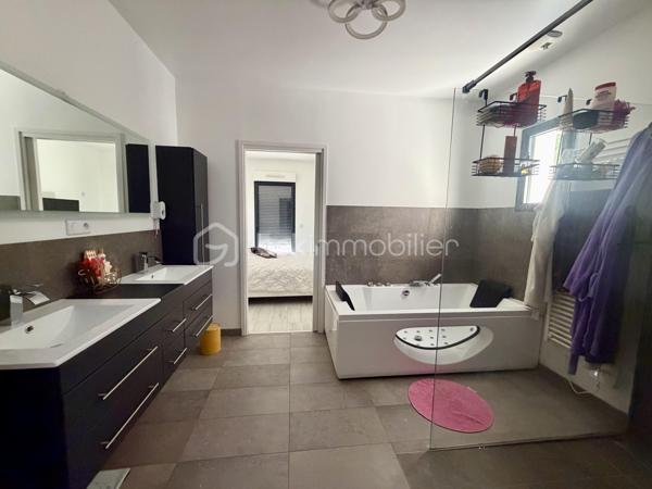 Située dans un cadre privilégié, en lot arrière, à l’abri des regards, cette remarquable maison contemporaine de 208 m² érigée en 2021 sur une parcelle de 951 m² vous offre un cadre de vie d’exception alliant confort absolu, prestations haut de gamme et tranquillité.

Toutes les commodités — écoles, commerces, transports — sont accessibles à moins de 10 minutes à pied, un atout rare qui conjugue vie au vert et praticité du quotidien.

LE REZ-DE-CHAUSSÉE:
Dès l’entrée, vous serez saisi par le volume exceptionnel du séjour triple baigné de lumière, de plus de 70 m², orienté Est-Ouest, ouvert sur le jardin et sa piscine. La cuisine américaine, entièrement aménagée et équipée, s’intègre avec élégance dans cet espace de vie généreux, idéal pour recevoir.

Le rez-de-chaussée comprend également :
	•	Une suite parentale de 28 m² avec dressing, salle de bains dotée d’une douche à l’italienne et d’une baignoire balnéo — un véritable espace bien-être privatif
	•	Un cellier
	•	Un WC suspendu indépendant
	•	Un double garage de 45 m² avec coin buanderie et mezzanine de 28 m² utiles, offrant un potentiel d’aménagement supplémentaire considérable

L’ÉTAGE:
L’étage est dédié au repos et à l’intimité de chacun. Il se compose de :
	•	3 suites de 28 m² chacune, toutes dotées d’un dressing et desservies par 1 salle de bains et 2 salles d’eau
	•	1 chambre d’amis de 15 m²
	•	Un WC suspendu indépendant

Une configuration idéale pour les familles nombreuses ou pour accueillir les proches dans les meilleures conditions.

LES EXTÉRIEURS:
L’extérieur est à la hauteur de l’intérieur. Une allée de 250 m² dessert la propriété et offre de nombreuses places de stationnement, complétées par des emplacements libres dans la rue.

Le terrain d’environ 700 m² accueille :
	•	Une terrasse de 40 m², parfaite pour les beaux jours
	•	Une piscine 8 x 3,5 m avec plage, chauffée par pompe à chaleur, équipée d’un volet électrique et d’un local technique dédié

LES ATOUTS TECHNIQUES:
Cette maison a été construite avec des matériaux de qualité supérieure et bénéficie de toutes les garanties :

	•	✅ Garantie décennale & dommages-ouvrage (construction 2021)
	•	✅ Construction en briques et escalier béton
	•	✅ Chauffage au sol par pompe à chaleur géothermique, complété par des radiateurs au gaz
	•	✅ Ballon thermodynamique
	•	✅ Norme RT 2012 — performance énergétique maîtrisée
	•	✅ 2 puisards pour une gestion optimale des eaux

Une propriété rare, clé en main, sans aucun travaux à prévoir. À visiter absolument.

Prix de vente : 800 000 €

Visite virtuelle disponible très prochainement ! 

Conseillère disponible 7j/7.
📞 Contactez-moi dès maintenant pour programmer votre visite.