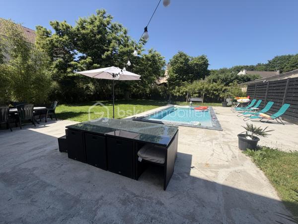 Située dans un cadre privilégié, en lot arrière, à l’abri des regards, cette remarquable maison contemporaine de 208 m² érigée en 2021 sur une parcelle de 951 m² vous offre un cadre de vie d’exception alliant confort absolu, prestations haut de gamme et tranquillité.

Toutes les commodités — écoles, commerces, transports — sont accessibles à moins de 10 minutes à pied, un atout rare qui conjugue vie au vert et praticité du quotidien.

LE REZ-DE-CHAUSSÉE:
Dès l’entrée, vous serez saisi par le volume exceptionnel du séjour triple baigné de lumière, de plus de 70 m², orienté Est-Ouest, ouvert sur le jardin et sa piscine. La cuisine américaine, entièrement aménagée et équipée, s’intègre avec élégance dans cet espace de vie généreux, idéal pour recevoir.

Le rez-de-chaussée comprend également :
	•	Une suite parentale de 28 m² avec dressing, salle de bains dotée d’une douche à l’italienne et d’une baignoire balnéo — un véritable espace bien-être privatif
	•	Un cellier
	•	Un WC suspendu indépendant
	•	Un double garage de 45 m² avec coin buanderie et mezzanine de 28 m² utiles, offrant un potentiel d’aménagement supplémentaire considérable

L’ÉTAGE:
L’étage est dédié au repos et à l’intimité de chacun. Il se compose de :
	•	3 suites de 28 m² chacune, toutes dotées d’un dressing et desservies par 1 salle de bains et 2 salles d’eau
	•	1 chambre d’amis de 15 m²
	•	Un WC suspendu indépendant

Une configuration idéale pour les familles nombreuses ou pour accueillir les proches dans les meilleures conditions.

LES EXTÉRIEURS:
L’extérieur est à la hauteur de l’intérieur. Une allée de 250 m² dessert la propriété et offre de nombreuses places de stationnement, complétées par des emplacements libres dans la rue.

Le terrain d’environ 700 m² accueille :
	•	Une terrasse de 40 m², parfaite pour les beaux jours
	•	Une piscine 8 x 3,5 m avec plage, chauffée par pompe à chaleur, équipée d’un volet électrique et d’un local technique dédié

LES ATOUTS TECHNIQUES:
Cette maison a été construite avec des matériaux de qualité supérieure et bénéficie de toutes les garanties :

	•	✅ Garantie décennale & dommages-ouvrage (construction 2021)
	•	✅ Construction en briques et escalier béton
	•	✅ Chauffage au sol par pompe à chaleur géothermique, complété par des radiateurs au gaz
	•	✅ Ballon thermodynamique
	•	✅ Norme RT 2012 — performance énergétique maîtrisée
	•	✅ 2 puisards pour une gestion optimale des eaux

Une propriété rare, clé en main, sans aucun travaux à prévoir. À visiter absolument.

Prix de vente : 800 000 €

Visite virtuelle disponible très prochainement ! 

Conseillère disponible 7j/7.
📞 Contactez-moi dès maintenant pour programmer votre visite.
