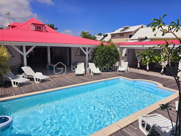 Jérôme MIGLIORE vous propose pour BSK IMMOBILLIER /

PROPRIETE D'EXCEPTION - 7 PIECES - UNIQUE A LA VENTE A  SAINT- FRANCOIS :

Située sur les hauteurs de Saint-François, à proximité immédiate du golf, de la marina, du casino, des plages, ainsi que de tous commerces et restaurants, cette superbe villa bénéficie d’un emplacement idéal au sein d’un lotissement paisible, offrant un cadre de vie des plus agréables.

D’une superficie de 181 m² de surface habitable ( habitation et annexes), cette demeure aux volumes généreux se compose de :

Un vaste séjour traversant de 50 m², lumineux et parfaitement ventilé, s’ouvrant sur deux terrasses,
Quatre chambres spacieuses, dont deux avec salle d’eau privative/ WC et une avec salle de bains avec WC,
Une mezzanine, idéale pour un espace bureau, bibliothèque, chambre ou salle de jeux,
Une cuisine indépendante avec office, fonctionnelle et bien agencée,
Bureau,
Un WC visiteurs.

Espaces extérieurs et équipements:
L’extérieur, conçu pour le confort et la convivialité, vous invite à la détente :
Une terrasse couverte avec un carbet équipé d’un jacuzzi (stores pour préserver votre intimité),
Une piscine au sel avec son deck, parfaite pour des moments de farniente sous le soleil des tropiques,
Un espace cuisine et salon extérieur, avec bar et barbecue, idéal pour recevoir famille et amis,
Un jardin arboré et parfaitement entretenu sur un terrain plat de 1 400 m² environ, entièrement clôturé, sans aucun vis-à-vis.

Autres atouts:
Capacité de stationnement pour 5 véhicules + Grand garage fermé de 45 m²,
Deux entrées indépendantes avec portails motorisés,
Construction 100 % béton, assurant une parfaite résistance aux conditions cycloniques,
Toiture révisée et repeinte en 2024,
Réserve d’eau de 2 000 litres,
Chauffe-eau solaire,
DPE réalisé en janvier 2025 – Classe B.

Un bien aux multiples possibilités,
Cette villa d’exception peut convenir aussi bien en résidence principale qu’en investissement locatif, avec un fort potentiel pour une activité de maison d’hôtes ou de locations saisonnières. De plus, une ou deux constructions supplémentaires de type bungalow peuvent être envisagées sur le terrain. ( zone U4 du PLU)

Un véritable havre de paix où luxe, confort et sérénité se conjuguent à la perfection.

Pour plus d’informations
Des vidéos du bien sont disponibles sur demande.

Ne manquez pas cette opportunité unique ! Contactez moi rapidement .