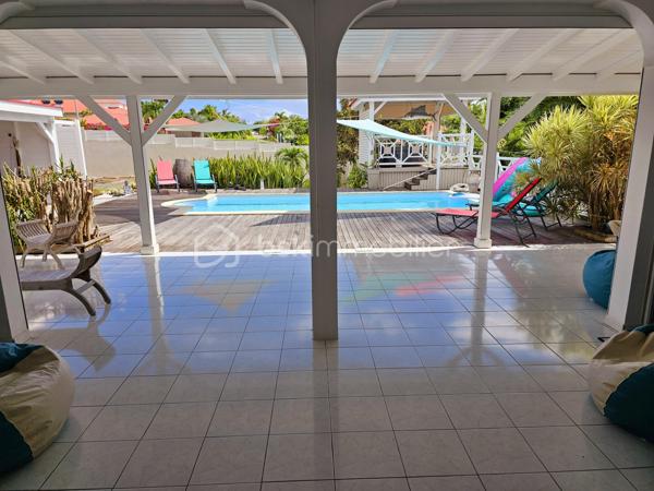 Jérôme MIGLIORE vous propose pour BSK IMMOBILLIER /

PROPRIETE D'EXCEPTION - 7 PIECES - UNIQUE A LA VENTE A  SAINT- FRANCOIS :

Située sur les hauteurs de Saint-François, à proximité immédiate du golf, de la marina, du casino, des plages, ainsi que de tous commerces et restaurants, cette superbe villa bénéficie d’un emplacement idéal au sein d’un lotissement paisible, offrant un cadre de vie des plus agréables.

D’une superficie de 181 m² de surface habitable ( habitation et annexes), cette demeure aux volumes généreux se compose de :

Un vaste séjour traversant de 50 m², lumineux et parfaitement ventilé, s’ouvrant sur deux terrasses,
Quatre chambres spacieuses, dont deux avec salle d’eau privative/ WC et une avec salle de bains avec WC,
Une mezzanine, idéale pour un espace bureau, bibliothèque, chambre ou salle de jeux,
Une cuisine indépendante avec office, fonctionnelle et bien agencée,
Bureau,
Un WC visiteurs.

Espaces extérieurs et équipements:
L’extérieur, conçu pour le confort et la convivialité, vous invite à la détente :
Une terrasse couverte avec un carbet équipé d’un jacuzzi (stores pour préserver votre intimité),
Une piscine au sel avec son deck, parfaite pour des moments de farniente sous le soleil des tropiques,
Un espace cuisine et salon extérieur, avec bar et barbecue, idéal pour recevoir famille et amis,
Un jardin arboré et parfaitement entretenu sur un terrain plat de 1 400 m² environ, entièrement clôturé, sans aucun vis-à-vis.

Autres atouts:
Capacité de stationnement pour 5 véhicules + Grand garage fermé de 45 m²,
Deux entrées indépendantes avec portails motorisés,
Construction 100 % béton, assurant une parfaite résistance aux conditions cycloniques,
Toiture révisée et repeinte en 2024,
Réserve d’eau de 2 000 litres,
Chauffe-eau solaire,
DPE réalisé en janvier 2025 – Classe B.

Un bien aux multiples possibilités,
Cette villa d’exception peut convenir aussi bien en résidence principale qu’en investissement locatif, avec un fort potentiel pour une activité de maison d’hôtes ou de locations saisonnières. De plus, une ou deux constructions supplémentaires de type bungalow peuvent être envisagées sur le terrain. ( zone U4 du PLU)

Un véritable havre de paix où luxe, confort et sérénité se conjuguent à la perfection.

Pour plus d’informations
Des vidéos du bien sont disponibles sur demande.

Ne manquez pas cette opportunité unique ! Contactez moi rapidement .