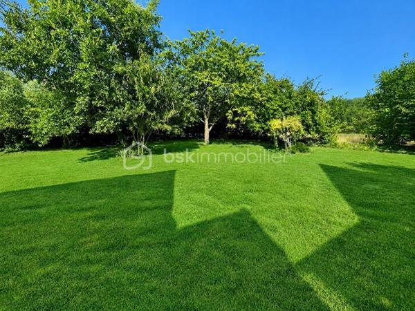 Laissez-vous séduire par cette authentique maison de caractère de 151 m², édifiée sur un magnifique terrain arboré de 1 712 m², offrant un cadre de vie rare et privilégié. Située dans un charmant village en pierre, face à la campagne et aux bois, sans aucun vis-à-vis, cette propriété est une véritable invitation à la sérénité.

Dès l’entrée, vous découvrirez une cuisine de 10 m² ouvrant sur une chaleureuse salle à manger, où les tomettes au sol, les poutres apparentes et sa cheminée témoignent du charme et de l’authenticité des lieux.

Le rez-de-chaussée se compose également d’une première chambre de 12 m², d’une salle d’eau, d’un WC indépendant, ainsi que d’un salon de 25 m², baigné de caractère avec ses tomettes, ses poutres apparentes et sa cheminée donnant accès a sa terrasse orienté sud ouest. Une seconde chambre de 18 m² complète ce niveau.

À l’étage, une vaste pièce de 33 m² au sol offre de multiples possibilités : grande chambre parentale, dortoir, salle de jeux ou espace de détente selon vos envies.

À l’extérieur, les prestations sont nombreuses :

    Une dépendance aménagée, comprenant une chambre avec sa salle d’eau et son WC, idéale pour recevoir famille et amis ou pour une activité indépendante.
    Une buanderie de 15 m², équipée d’un chauffe-eau solaire, d’un évier, avec les arrivées et évacuations prévues.
    Un local à vélos.
    Un local de jardinage.
    Une magnifique cave voûtée.
    Un garage.

La maison est équipée d’un assainissement individuel (fosse septique).

Cette propriété séduira les amoureux de nature, de calme et d’authenticité, à la recherche d’un environnement bucolique et préservé. Un bien rare, où le charme de l’ancien se marie parfaitement avec la quiétude de la campagne.

Une visite s’impose pour découvrir ce lieu de vie unique et plein de caractère.