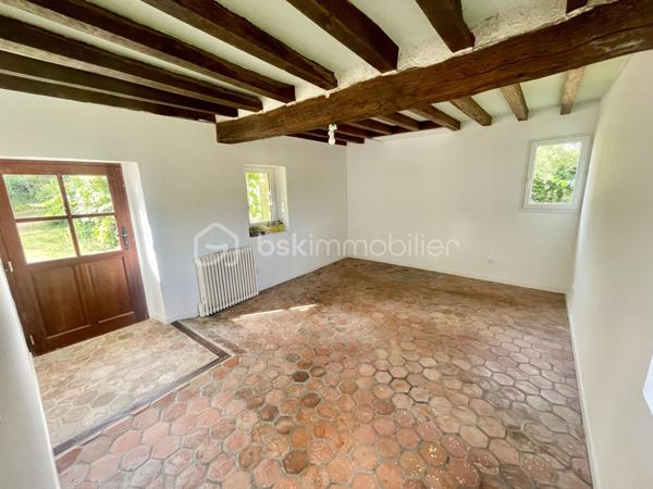 Laissez-vous séduire par cette authentique maison de caractère de 151 m², édifiée sur un magnifique terrain arboré de 1 712 m², offrant un cadre de vie rare et privilégié. Située dans un charmant village en pierre, face à la campagne et aux bois, sans aucun vis-à-vis, cette propriété est une véritable invitation à la sérénité.

Dès l’entrée, vous découvrirez une cuisine de 10 m² ouvrant sur une chaleureuse salle à manger, où les tomettes au sol, les poutres apparentes et sa cheminée témoignent du charme et de l’authenticité des lieux.

Le rez-de-chaussée se compose également d’une première chambre de 12 m², d’une salle d’eau, d’un WC indépendant, ainsi que d’un salon de 25 m², baigné de caractère avec ses tomettes, ses poutres apparentes et sa cheminée donnant accès a sa terrasse orienté sud ouest. Une seconde chambre de 18 m² complète ce niveau.

À l’étage, une vaste pièce de 33 m² au sol offre de multiples possibilités : grande chambre parentale, dortoir, salle de jeux ou espace de détente selon vos envies.

À l’extérieur, les prestations sont nombreuses :

    Une dépendance aménagée, comprenant une chambre avec sa salle d’eau et son WC, idéale pour recevoir famille et amis ou pour une activité indépendante.
    Une buanderie de 15 m², équipée d’un chauffe-eau solaire, d’un évier, avec les arrivées et évacuations prévues.
    Un local à vélos.
    Un local de jardinage.
    Une magnifique cave voûtée.
    Un garage.

La maison est équipée d’un assainissement individuel (fosse septique).

Cette propriété séduira les amoureux de nature, de calme et d’authenticité, à la recherche d’un environnement bucolique et préservé. Un bien rare, où le charme de l’ancien se marie parfaitement avec la quiétude de la campagne.

Une visite s’impose pour découvrir ce lieu de vie unique et plein de caractère.