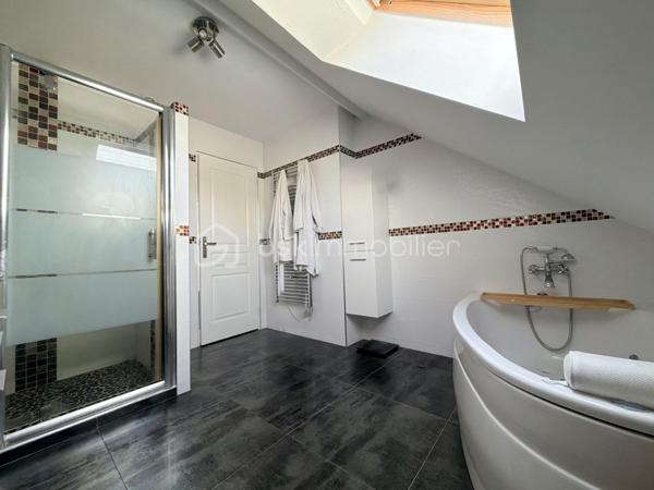 Au rez-de-chaussée, vous serez séduit par une agréable pièce de vie composée d’un double salon-séjour convivial d'environ 30m2 avec poêle à bois et climatisation, ouverte sur une cuisine aménagée et équipée. Un WC indépendant complète ce niveau.

À l’étage, le palier dessert 3 belles chambres spacieuses, une salle de bains avec baignoire balnéo et douche, ainsi qu’un WC indépendant.

Le troisième niveau offre un véritable espace supplémentaire grâce aux combles aménagés, permettant d’optimiser le rangement et de créer un bureau ou une chambre d’appoint selon vos envies. Il est également possible d’y installer un WC.

La maison bénéficie également d’un grand garage attenant, idéal pour stationner et profiter d’un espace de rangement supplémentaire.

À l’extérieur, vous profiterez pleinement d’un terrain clos, à l’abri des regards et sans vis-à-vis, offrant un cadre agréable et intimiste. Une belle cuisine d’été invite aux moments conviviaux en famille ou entre amis, tandis qu’un cabanon complète les espaces extérieurs.

Une maison fonctionnelle, chaleureuse et pleine de potentiel, qui saura séduire ceux à la recherche d’un environnement agréable et d’espaces bien pensés. Une visite s’impose !