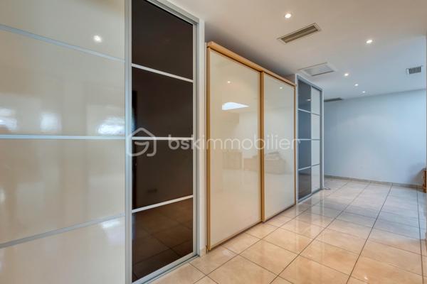 VIF (38450) – Ensemble immobilier avec habitation et local d’activité – 182 m² habitables – Atelier de 76 m² – Terrain de 825 m²

BSK Immobilier – Nicolas Sapin vous propose à la vente un ensemble immobilier rare, idéal pour un artisan, un entrepreneur ou un professionnel souhaitant réunir son activité et son lieu de vie sur une même propriété.

Situé à Vif, sur l’avenue du Général-de-Gaulle, ce bien bénéficie d’un accès rapide aux principaux axes tout en offrant un environnement mêlant activité professionnelle et habitat résidentiel.

Édifié en 2002 sur une parcelle de 825 m², cet ensemble se compose d’une maison d’habitation d’environ 182 m² et d’un espace professionnel de 76 m² comprenant un atelier ainsi que plusieurs zones de stockage. La propriété dispose également d’une terrasse, d’un jardin et d’une vaste cour permettant le stationnement de plusieurs véhicules.

Une habitation familiale aux beaux volumes

Dès l’entrée, vous découvrirez une maison pensée pour le confort du quotidien.

Le rez-de-chaussée accueille une belle pièce de vie de plus de 60 m², composée d’un salon-séjour lumineux ouvert sur une cuisine semi-ouverte entièrement aménagée et équipée avec son espace repas. Une suite parentale avec salle d’eau privative, une salle de bains, une buanderie ainsi qu’un WC indépendant complètent ce niveau.

À l’étage, l’espace nuit propose trois chambres supplémentaires, une salle d’eau avec WC ainsi qu’un vaste espace bureau de plus de 30 m² pouvant facilement être aménagé en salle de jeux, espace détente, salle de sport ou cinquième chambre selon vos besoins.

Un véritable outil de travail

Attenant à l’habitation, le local professionnel comprend un atelier/garage d’environ 56 m² complété par deux espaces de stockage d’environ 5 m² et 15 m².

Cette configuration conviendra parfaitement à un artisan, une entreprise ou une profession nécessitant un espace de stockage, un atelier ou un garage tout en profitant d’un logement de fonction directement sur place.

Prestations

Construction de 2002
Terrain de 825 m²
Chauffage par pompe à chaleur air/eau
Chauffage au sol au rez-de-chaussée
Climatisation réversible à l’étage
Menuiseries double vitrage
Volets roulants
Ballon d’eau chaude de 200 litres
VMC
Terrasse
Jardin
Cour de stationnement
Performances énergétiques

DPE : B
GES : A
Estimation des dépenses annuelles d’énergie : entre 1 360 € et 1 900 € (abonnements compris).
Informations importantes

Ce bien est implanté dans une zone à vocation artisanale et a été autorisé en tant que local d’activité avec logement de fonction. Il s’adresse principalement à un professionnel souhaitant exercer son activité tout en résidant sur place.

Un bien rare sur le secteur, offrant une solution idéale pour conjuguer vie professionnelle et vie familiale dans un même ensemble immobilier.

Pour tout renseignement complémentaire ou organiser une visite, contactez Nicolas Sapin – BSK Immobilier.