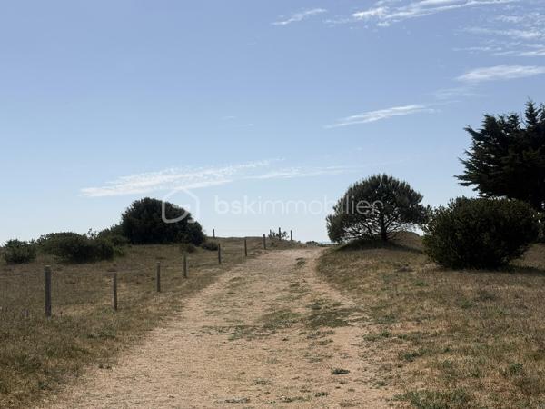 Sur l’Île de Noirmoutier, à Barbâtre, cette maison entièrement rénovée bénéficie d’un emplacement particulièrement recherché, à seulement 160 mètres de la plage, accessible à pied par un chemin menant directement à la dune.

À l’avant de la propriété, la vue s’ouvre en direction de la baie et du passage du Gois, offrant une atmosphère typiquement noirmoutrine.

Dès l’entrée, les volumes et la luminosité s’imposent naturellement. La pièce de vie, d’environ 60 m², accueille cuisine, salle à manger et salon dans une continuité fluide, largement ouverte sur les terrasses. Les nombreuses ouvertures prolongent les espaces vers l’extérieur et créent une véritable qualité de vie au quotidien.

La rénovation, menée avec exigence, met en valeur des matériaux de qualité et des finitions soignées. Les sols en bois massif apportent chaleur et élégance, tandis que la cuisine intégrée, aménagée et équipée, avec îlot central, s’inscrit dans un esprit contemporain et fonctionnel.

La maison propose une organisation idéale avec deux espaces nuit distincts :

• une première aile composée de deux chambres, avec salle d’eau et WC  
• une seconde aile dédiée à une suite parentale avec dressing, salle d’eau et WC  

Chaque chambre dispose d’un accès direct vers l’extérieur, renforçant le confort et l’indépendance de chacun.

Une buanderie complète les espaces du quotidien.

La maison développe environ 120 m² habitables.

Elle est complétée par une pièce indépendante d’environ 20 m², entièrement rénovée et isolée. Non comptabilisée en surface habitable en l’absence de chauffage, elle constitue néanmoins un espace complémentaire facilement aménageable selon les besoins.

À l’extérieur, deux terrasses carrelées prolongent les espaces de vie. Le terrain, volontairement laissé libre d’aménagement, permet à chacun de s’approprier les lieux selon ses envies.

Un second bâtiment indépendant vient compléter l’ensemble et pourra, après remise en état, être aménagé en garage ou en espace de stockage.

Côté confort, la maison est équipée d’une pompe à chaleur avec plancher chauffant, assurant un confort thermique homogène et performant.  
La performance énergétique est classée B.

Son emplacement, sur la commune de Barbâtre, permet de profiter pleinement du cadre de vie de l’Île de Noirmoutier tout en conservant une circulation fluide vers le continent.

Une maison aux prestations soignées, offrant un équilibre rare entre confort, luminosité et proximité immédiate du littoral.
Je me tiens à votre disposition pour organiser une découverte du bien dans des conditions privilégiées, en m’adaptant pleinement à vos disponibilités.
Je vous accompagne également dans votre projet dans sa globalité, avec une approche personnalisée à chaque étape.
Sandrine MATHELIN  
Mandataire immobilier – BSK Immobilier  
06 56 88 64 65  
smathelin@bskimmobilier.com  

Joignable du lundi au samedi de 8h30 à 20h30