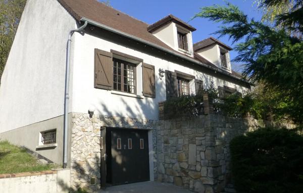 Maison avec sous-sol total et terrain arboré.