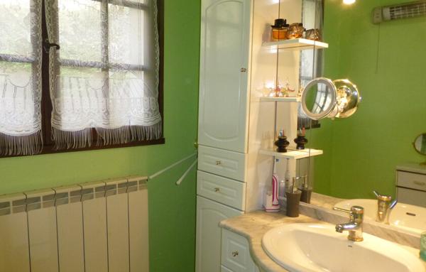 Maison avec sous-sol total et terrain arboré.