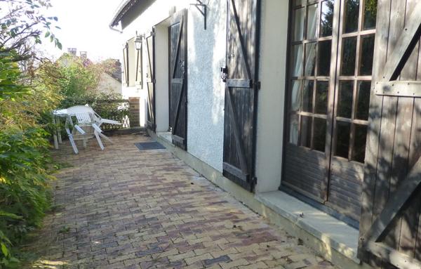 Maison avec sous-sol total et terrain arboré.