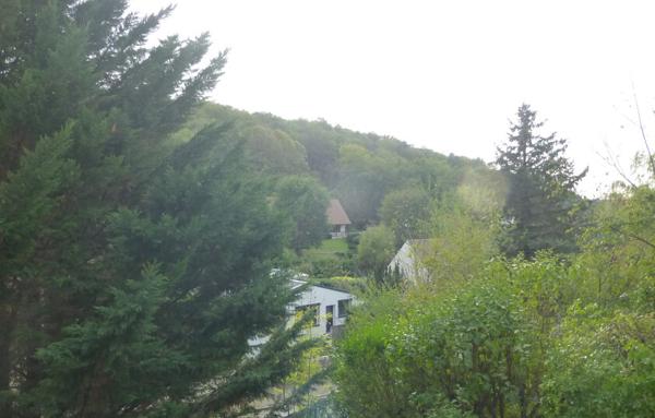 Maison avec sous-sol total et terrain arboré.