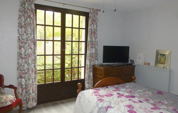 Maison avec sous-sol total et terrain arboré.