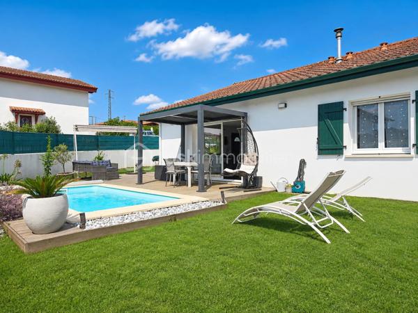 Maison contemporaine de plain-pied avec piscine – 4 chambres – Proche Bayonne

  Un véritable coup de cœur à découvrir sans tarder !

Dans un environnement calme et résidentiel, découvrez cette jolie maison contemporaine de 2017, 
entièrement de plain-pied, implantée sur une parcelle clôturée de 413 m².

Idéalement située, vous serez à seulement  5 minutes du centre commercial Ametzondo et 10 minutes de Bayonne.

    - VISITE VIRTUELLE SUR DEMANDE - GRATUITE

Dès l'entrée, vous serez séduits par une belle pièce de vie lumineuse de 43 m², chaleureuse et conviviale, 
agrémentée d'un poêle à granulés. 
Elle s'ouvre directement sur les extérieurs et la piscine.

La cuisine ouverte, aménagée et équipée, s'intègre parfaitement à cet espace de vie pensé pour profiter pleinement 
des moments en famille ou entre amis.

Un espace nuit confortable :

La maison propose 4 chambres, dont une belle **suite parentale** avec :

* dressing,
* salle d'eau avec douche à l'italienne,
* WC.

Un cellier avec accès au garage, une seconde salle d'eau et un WC indépendant viennent compléter l'espace intérieur.

Un extérieur pensé pour profiter pleinement des beaux jours.

Vous apprécierez particulièrement son jardin clos et facile à vivre, ainsi que ses deux terrasses exposées Sud-Ouest.

L'une bénéficie d'une pergola, l'autre d'un store, permettant de profiter des extérieurs à différents moments de la journée.

Et pour les journées ensoleillées : place à la détente avec une piscine chauffée et équipée d'une filtration au sel ! 

Un garage de 15 m² complète l'ensemble.

Les prestations : 

* Maison récente de 2017
* Plain-pied
* 4 chambres
* Piscine chauffée avec filtration au sel
* Poêle à granulés + chauffage électrique
* Eau chaude par ballon thermodynamique
* Huisseries PVC double vitrage
* Volets roulants électriques et bois
* VMC
* Moustiquaires
* Fibre
* Tout-à-l'égout
* Garage de 15 m²

  Les + qui font la différence :

Plain-pied • Maison récente • Excellent diagnostic performance énergétique classé en A et A • 4 chambres • Piscine • Jardin clos
• Terrasses • Calme • Proximité Bayonne

Une maison fonctionnelle, lumineuse et parfaitement adaptée à une vie de famille, où tout est réuni pour profiter 
d'un cadre de vie agréable à proximité immédiate de Bayonne.

Une maison coup de cœur qui ne devrait pas rester longtemps sur le marché… Alors, ne tardez pas !

 Je suis à votre écoute 7 jours sur 7 et m'adapte à votre planning pour organiser votre visite.
