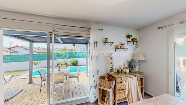 Maison contemporaine de plain-pied avec piscine – 4 chambres – Proche Bayonne

  Un véritable coup de cœur à découvrir sans tarder !

Dans un environnement calme et résidentiel, découvrez cette jolie maison contemporaine de 2017, 
entièrement de plain-pied, implantée sur une parcelle clôturée de 413 m².

Idéalement située, vous serez à seulement  5 minutes du centre commercial Ametzondo et 10 minutes de Bayonne.

    - VISITE VIRTUELLE SUR DEMANDE - GRATUITE

Dès l'entrée, vous serez séduits par une belle pièce de vie lumineuse de 43 m², chaleureuse et conviviale, 
agrémentée d'un poêle à granulés. 
Elle s'ouvre directement sur les extérieurs et la piscine.

La cuisine ouverte, aménagée et équipée, s'intègre parfaitement à cet espace de vie pensé pour profiter pleinement 
des moments en famille ou entre amis.

Un espace nuit confortable :

La maison propose 4 chambres, dont une belle **suite parentale** avec :

* dressing,
* salle d'eau avec douche à l'italienne,
* WC.

Un cellier avec accès au garage, une seconde salle d'eau et un WC indépendant viennent compléter l'espace intérieur.

Un extérieur pensé pour profiter pleinement des beaux jours.

Vous apprécierez particulièrement son jardin clos et facile à vivre, ainsi que ses deux terrasses exposées Sud-Ouest.

L'une bénéficie d'une pergola, l'autre d'un store, permettant de profiter des extérieurs à différents moments de la journée.

Et pour les journées ensoleillées : place à la détente avec une piscine chauffée et équipée d'une filtration au sel ! 

Un garage de 15 m² complète l'ensemble.

Les prestations : 

* Maison récente de 2017
* Plain-pied
* 4 chambres
* Piscine chauffée avec filtration au sel
* Poêle à granulés + chauffage électrique
* Eau chaude par ballon thermodynamique
* Huisseries PVC double vitrage
* Volets roulants électriques et bois
* VMC
* Moustiquaires
* Fibre
* Tout-à-l'égout
* Garage de 15 m²

  Les + qui font la différence :

Plain-pied • Maison récente • Excellent diagnostic performance énergétique classé en A et A • 4 chambres • Piscine • Jardin clos
• Terrasses • Calme • Proximité Bayonne

Une maison fonctionnelle, lumineuse et parfaitement adaptée à une vie de famille, où tout est réuni pour profiter 
d'un cadre de vie agréable à proximité immédiate de Bayonne.

Une maison coup de cœur qui ne devrait pas rester longtemps sur le marché… Alors, ne tardez pas !

 Je suis à votre écoute 7 jours sur 7 et m'adapte à votre planning pour organiser votre visite.