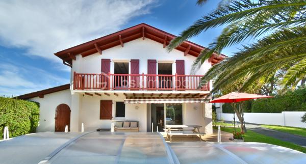 A 200 mètres à pied de la place du village et des plages, cette maison néo-basque bénéficie d'un emplacement que l'on trouve très rarement à Bidart : central, au calme et côté océan.
Développant environ 215 m2 sur un terrain de 1000 m2, la maison offre aujourd'hui 5 chambres, 2 salles de bain, une cuisine indépendante avec arrière cuisine et un séjour lumineux ouvert sur l'extérieur. La terrasse plein Sud avec piscine prolonge naturellement les espaces de vie et permet de profiter pleinement du cadre. Garage, atelier et abri de piscine complètent l'ensemble. La maison est parfaitement entretenue, mais nécessite une remise au goût du jour. Le potentiel est évident pour qui souhaite créer un lieu de vie à la hauteur de l'adresse. Ici, la vraie valeur n'est pas seulement dans la maison, mais dans ce qu'elle permet : vivre Bidart à pied, entre village et océan, dans un environnement préservé. Ce type de bien ne se juge pas sur ses photos. Il se découvre sur place. Visite sur rendez-vous.