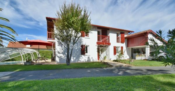 A 200 mètres à pied de la place du village et des plages, cette maison néo-basque bénéficie d'un emplacement que l'on trouve très rarement à Bidart : central, au calme et côté océan.
Développant environ 215 m2 sur un terrain de 1000 m2, la maison offre aujourd'hui 5 chambres, 2 salles de bain, une cuisine indépendante avec arrière cuisine et un séjour lumineux ouvert sur l'extérieur. La terrasse plein Sud avec piscine prolonge naturellement les espaces de vie et permet de profiter pleinement du cadre. Garage, atelier et abri de piscine complètent l'ensemble. La maison est parfaitement entretenue, mais nécessite une remise au goût du jour. Le potentiel est évident pour qui souhaite créer un lieu de vie à la hauteur de l'adresse. Ici, la vraie valeur n'est pas seulement dans la maison, mais dans ce qu'elle permet : vivre Bidart à pied, entre village et océan, dans un environnement préservé. Ce type de bien ne se juge pas sur ses photos. Il se découvre sur place. Visite sur rendez-vous.