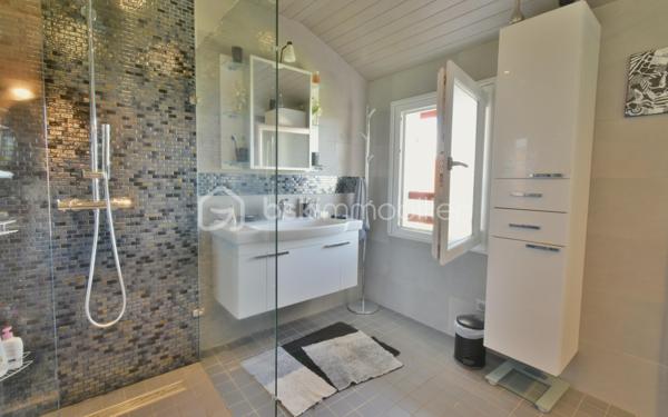 A 200 mètres à pied de la place du village et des plages, cette maison néo-basque bénéficie d'un emplacement que l'on trouve très rarement à Bidart : central, au calme et côté océan.
Développant environ 215 m2 sur un terrain de 1000 m2, la maison offre aujourd'hui 5 chambres, 2 salles de bain, une cuisine indépendante avec arrière cuisine et un séjour lumineux ouvert sur l'extérieur. La terrasse plein Sud avec piscine prolonge naturellement les espaces de vie et permet de profiter pleinement du cadre. Garage, atelier et abri de piscine complètent l'ensemble. La maison est parfaitement entretenue, mais nécessite une remise au goût du jour. Le potentiel est évident pour qui souhaite créer un lieu de vie à la hauteur de l'adresse. Ici, la vraie valeur n'est pas seulement dans la maison, mais dans ce qu'elle permet : vivre Bidart à pied, entre village et océan, dans un environnement préservé. Ce type de bien ne se juge pas sur ses photos. Il se découvre sur place. Visite sur rendez-vous.