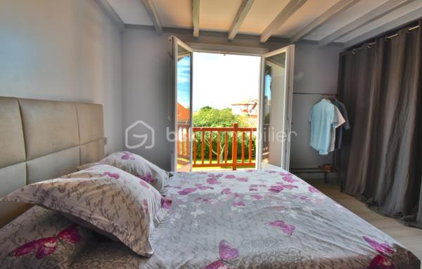 A 200 mètres à pied de la place du village et des plages, cette maison néo-basque bénéficie d'un emplacement que l'on trouve très rarement à Bidart : central, au calme et côté océan.
Développant environ 215 m2 sur un terrain de 1000 m2, la maison offre aujourd'hui 5 chambres, 2 salles de bain, une cuisine indépendante avec arrière cuisine et un séjour lumineux ouvert sur l'extérieur. La terrasse plein Sud avec piscine prolonge naturellement les espaces de vie et permet de profiter pleinement du cadre. Garage, atelier et abri de piscine complètent l'ensemble. La maison est parfaitement entretenue, mais nécessite une remise au goût du jour. Le potentiel est évident pour qui souhaite créer un lieu de vie à la hauteur de l'adresse. Ici, la vraie valeur n'est pas seulement dans la maison, mais dans ce qu'elle permet : vivre Bidart à pied, entre village et océan, dans un environnement préservé. Ce type de bien ne se juge pas sur ses photos. Il se découvre sur place. Visite sur rendez-vous.