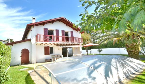 A 200 mètres à pied de la place du village et des plages, cette maison néo-basque bénéficie d'un emplacement que l'on trouve très rarement à Bidart : central, au calme et côté océan.
Développant environ 215 m2 sur un terrain de 1000 m2, la maison offre aujourd'hui 5 chambres, 2 salles de bain, une cuisine indépendante avec arrière cuisine et un séjour lumineux ouvert sur l'extérieur. La terrasse plein Sud avec piscine prolonge naturellement les espaces de vie et permet de profiter pleinement du cadre. Garage, atelier et abri de piscine complètent l'ensemble. La maison est parfaitement entretenue, mais nécessite une remise au goût du jour. Le potentiel est évident pour qui souhaite créer un lieu de vie à la hauteur de l'adresse. Ici, la vraie valeur n'est pas seulement dans la maison, mais dans ce qu'elle permet : vivre Bidart à pied, entre village et océan, dans un environnement préservé. Ce type de bien ne se juge pas sur ses photos. Il se découvre sur place. Visite sur rendez-vous.