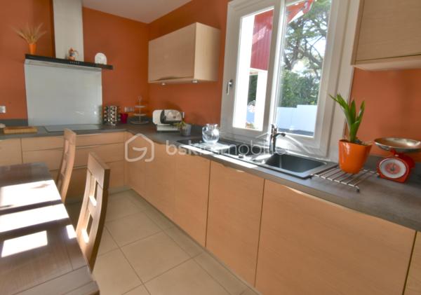 A 200 mètres à pied de la place du village et des plages, cette maison néo-basque bénéficie d'un emplacement que l'on trouve très rarement à Bidart : central, au calme et côté océan.
Développant environ 215 m2 sur un terrain de 1000 m2, la maison offre aujourd'hui 5 chambres, 2 salles de bain, une cuisine indépendante avec arrière cuisine et un séjour lumineux ouvert sur l'extérieur. La terrasse plein Sud avec piscine prolonge naturellement les espaces de vie et permet de profiter pleinement du cadre. Garage, atelier et abri de piscine complètent l'ensemble. La maison est parfaitement entretenue, mais nécessite une remise au goût du jour. Le potentiel est évident pour qui souhaite créer un lieu de vie à la hauteur de l'adresse. Ici, la vraie valeur n'est pas seulement dans la maison, mais dans ce qu'elle permet : vivre Bidart à pied, entre village et océan, dans un environnement préservé. Ce type de bien ne se juge pas sur ses photos. Il se découvre sur place. Visite sur rendez-vous.