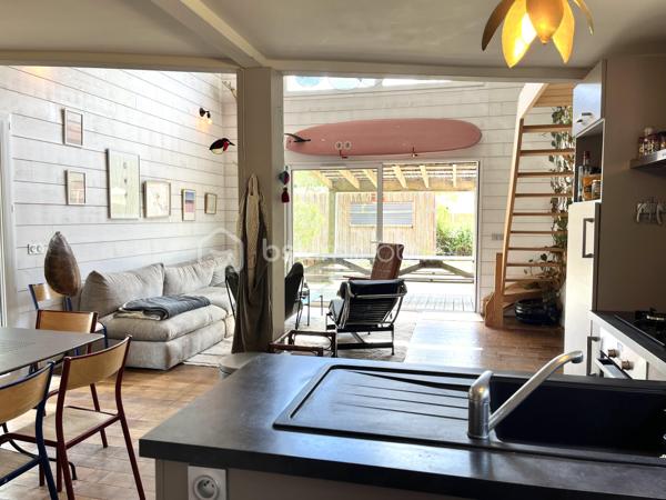Dans un écrin de verdure, découvrez cette maison en ossature bois de 2016, parfaitement entretenue et réalisée avec des matériaux de qualité, offrant environ 85 m² habitables Loi Carrez complétés par une mezzanine mansardée pour atteindre environ 100 m² hors Loi Carrez.
Baignée de lumière grâce à son exposition plein sud, elle propose un séjour chaleureux avec une belle hauteur sous plafond et une cuisine ouverte, trois chambres dont une en mezzanine, une salle de bain avec baignoire à l’étage, une salle d’eau au rez-de-chaussée ainsi que deux WC. Un espace buanderie/cellier vient compléter la maison. 
Confort moderne assuré avec volets roulants électriques, climatisation réversible, raccordement au tout-à-l’égout et puits foré pour l’arrosage du jardin. À l’extérieur, un garage et un container aménagé, raccordé à l’eau et à l’électricité, pouvant faire office de cuisine d’été, viennent compléter ce bien d'exception.

Cette maison allie à la perfection le confort moderne et le charme et l'authenticité du bois et de la luminosité naturelle.
A visiter sans tarder !