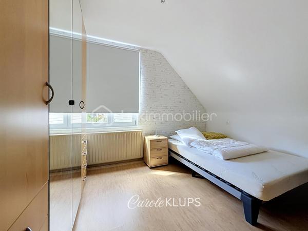 Maison familiale avec véranda, terrasse couverte, jardin et piscine à Village-Neuf

Ici, la surface habitable ne raconte pas tout. 112 m² habitables auxquels s’ajoutent une véranda d’environ 10 m², une terrasse couverte tournée vers le jardin, un sous-sol et un double garage. 

Le charme d’une maison des années 30 dans laquelle on peut se créer une véritable vie dedans-dehors, à deux pas de la frontière bâloise. Et pour les frontaliers, Bâle est accessible à vélo via la piste cyclable longeant le canal de Huningue.

Depuis la rue, on ne soupçonne pas le cadre de vie que cette maison réserve à l’arrière.

Résolument tournée vers l’extérieur, elle s’ouvre sur un jardin intimiste où chaque espace trouve naturellement sa place. Une belle terrasse couverte pour les repas entre amis ou en famille. À moins que vous ne préfériez vous installer au bord de la piscine chauffée … Autour, l’espace paysager invite au repos et à la convivialité.

Une sensation de vacances chez soi, avec un autre avantage appréciable : un jardin aux dimensions raisonnables, pensé pour en profiter sans devenir esclave de son entretien. Un puits présent sur la propriété permet par ailleurs d’assurer l’arrosage du jardin.

À l’intérieur aussi, chaque espace a sa fonction et la circulation est fluide.

Au rez-de-chaussée, le séjour de 32,6 m² invite à se prélasser près du poêle à bois. La cuisine équipée de 12 m² offre un espace confortable pour cuisiner, tandis que la véranda d’environ 10 m² devient naturellement une pièce supplémentaire pour partager les repas, avec le jardin en toile de fond.

Le + de ce rez-de-chaussée ? Une salle d’eau avec WC.

En montant à l’étage, même le palier a été optimisé avec un petit espace buanderie astucieusement dissimulé.

Puis vient l’une des belles surprises de la maison : une vaste mezzanine de plus de 23 m².

Aujourd’hui ouverte, elle sera votre terrain de jeu. Espace télétravail, bibliothèque, salle de jeux pour les enfants, salon télé… à chacun d’imaginer sa façon de l’habiter. Elle pourra également être cloisonnée pour créer une troisième chambre, qui viendra alors compléter les deux chambres existantes de 12,6 et 11,2 m².

La salle de bains de 7,6 m², avec baignoire, double vasque et WC, est quant à elle dimensionnée pour ces matins en famille où l’on apprécie de ne pas se marcher dessus.

Et ce n’est pas tout.

Au sous-sol, on retrouve une partie chaufferie, un atelier ainsi qu’un espace déjà aménagé en salle de sport, à conserver tel quel ou à réinventer selon vos besoins.

À l’extérieur, le double garage, la piscine chauffée et son local technique indépendant complètent les prestations de la maison.

Le tout prend place sur une parcelle de 480 m².

Enfin, sa situation en zone frontalière, avec des accès faciles vers la Suisse comme vers l’Allemagne, est particulièrement adaptée à la vie quotidienne des actifs du secteur.

Une maison avec jardin et piscine, une vraie vie dedans-dehors et Bâle à portée de vélo : profiter pleinement de chez soi sans renoncer à la proximité de la frontière.